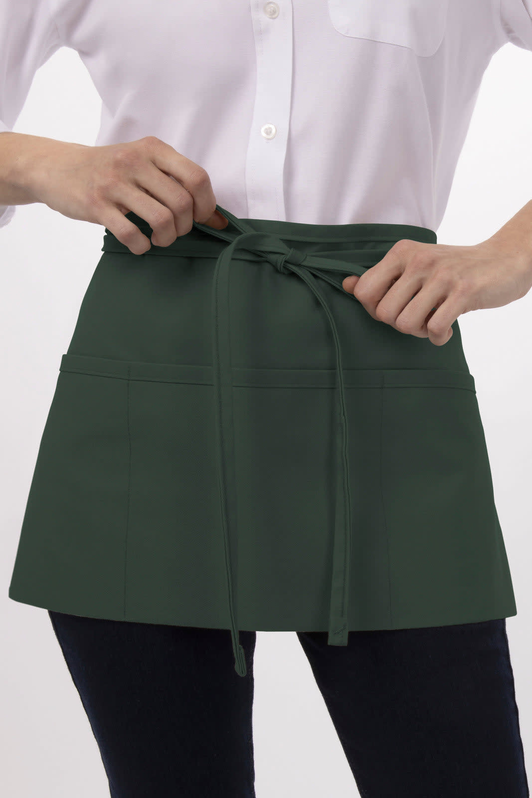 A dark green waist apron with ties, featuring pockets, worn over a white shirt.