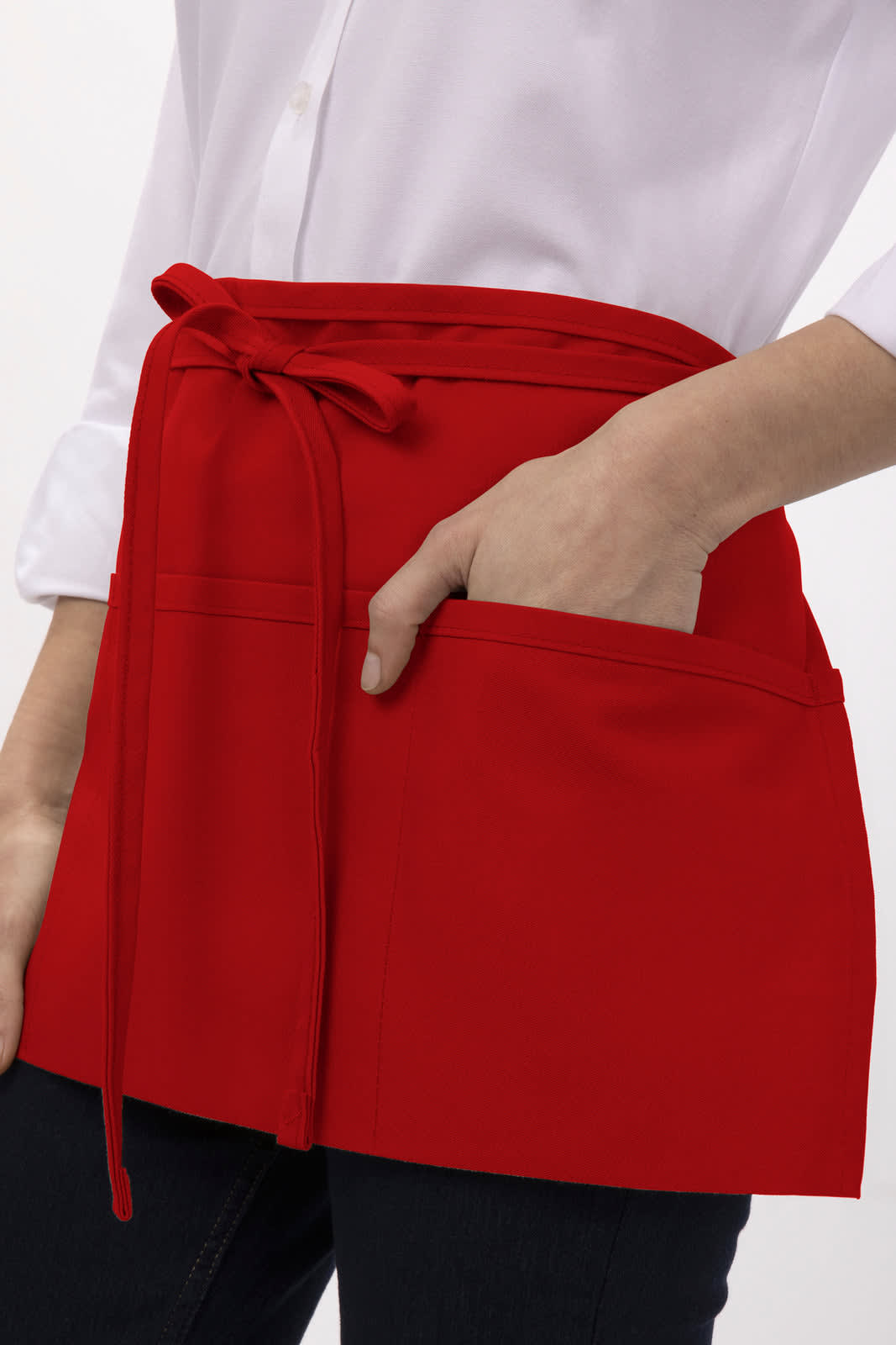 A red waist apron with a tied waistband and front pockets, featured on a model wearing a white shirt.