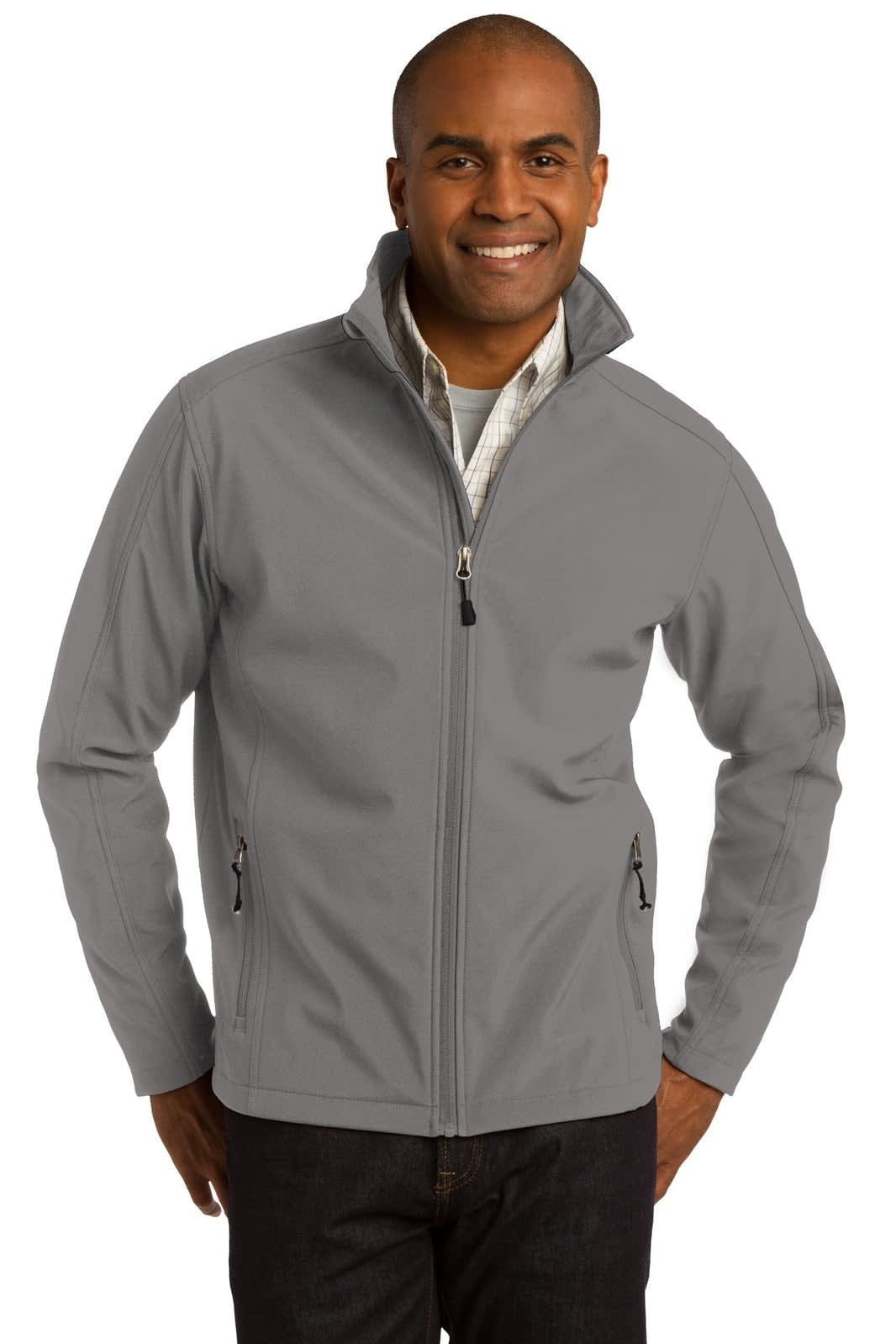 A man wearing a grey soft shell jacket with zippered pockets and a collar. The jacket has a logo on it.
