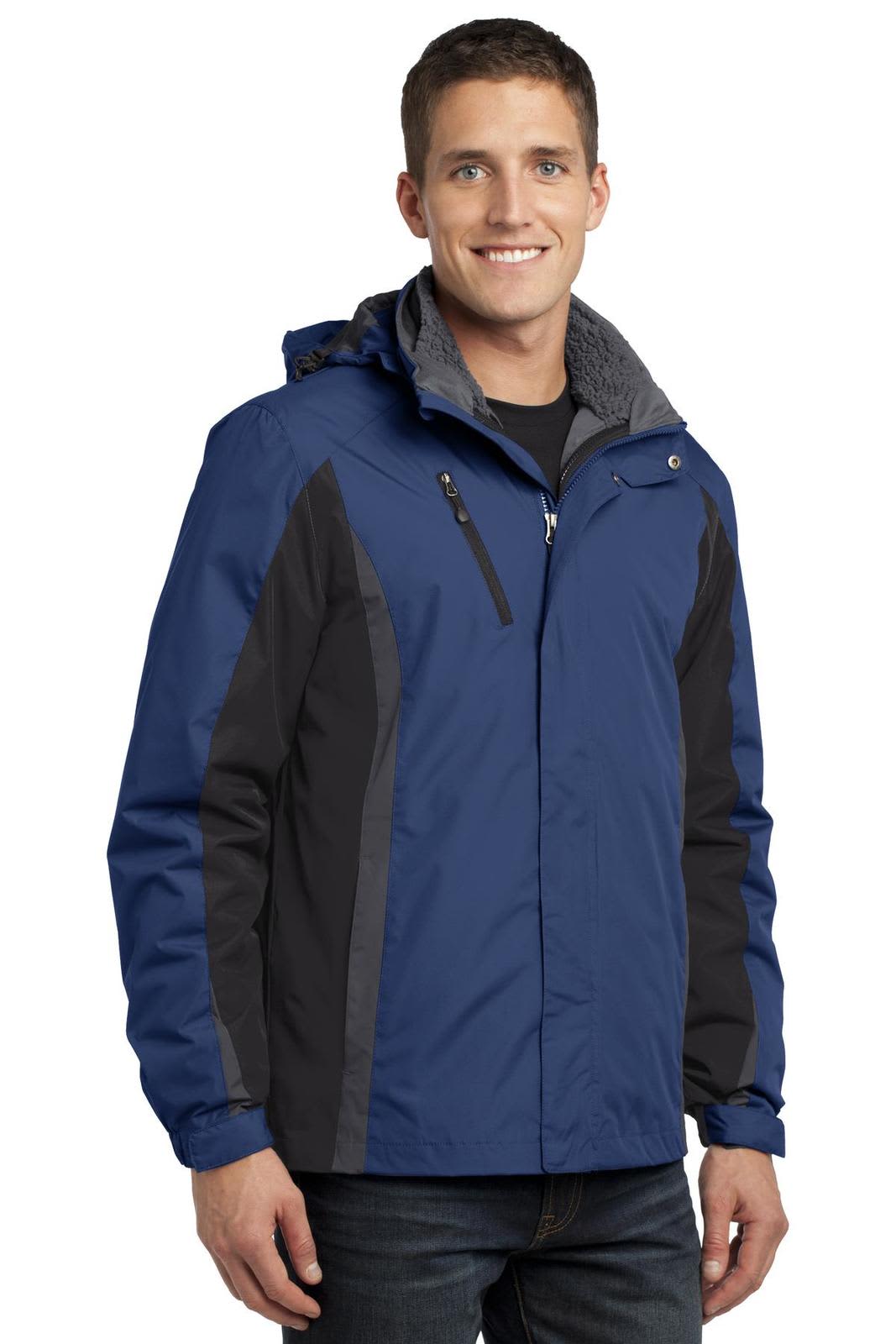 A man wearing a blue and black Port Authority Colorblock 3-in-1 jacket with a hood. The jacket has a zippered front and pocket.