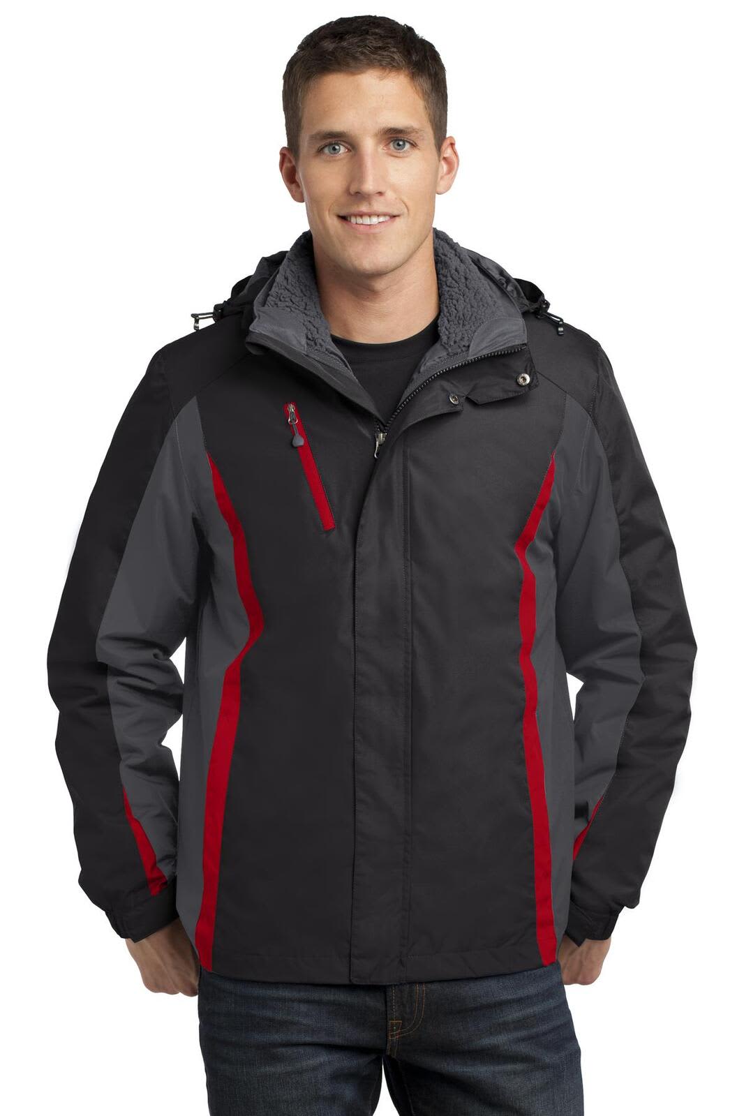 A man wearing a Port Authority 3-in-1 jacket featuring black, grey, and red colours, with a hood and zippered pockets.
