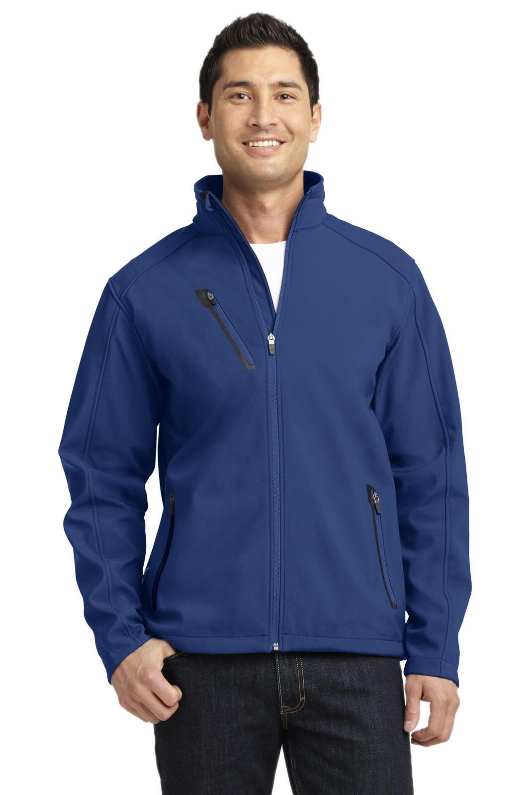 A man wearing a navy soft shell jacket with zippered pockets and a logo.