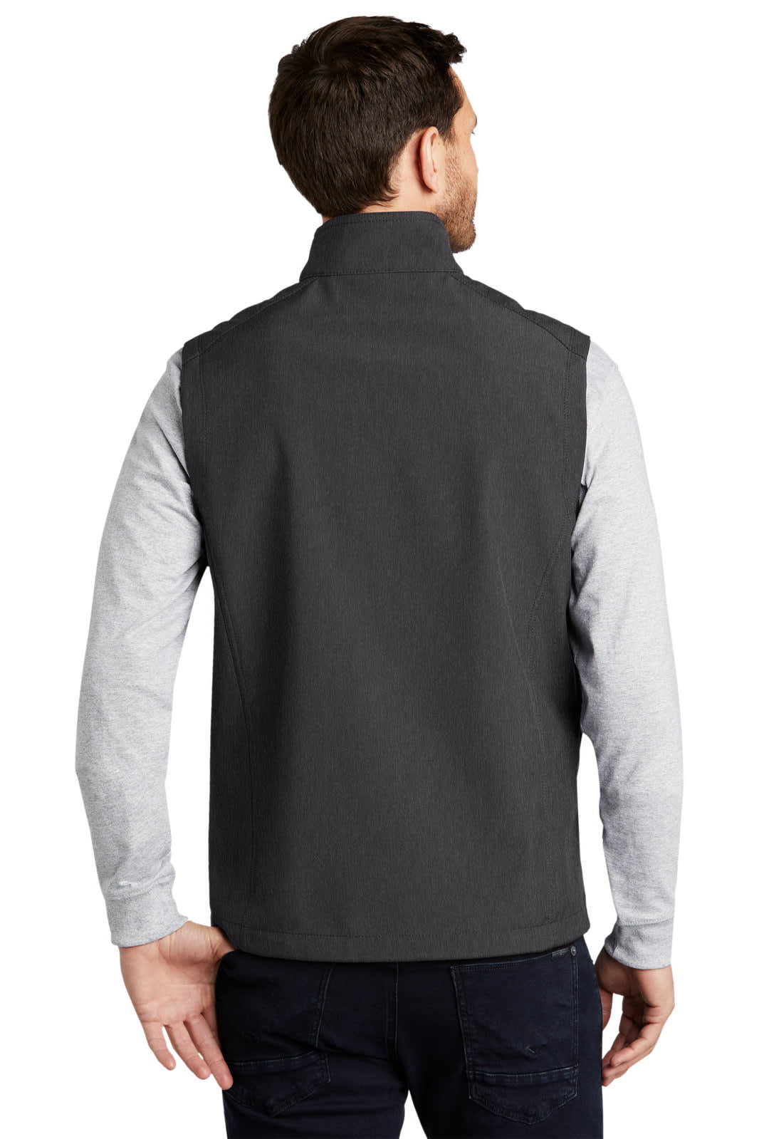 A man wearing a dark grey soft shell vest, with a collar, viewed from the back. The vest has a logo.