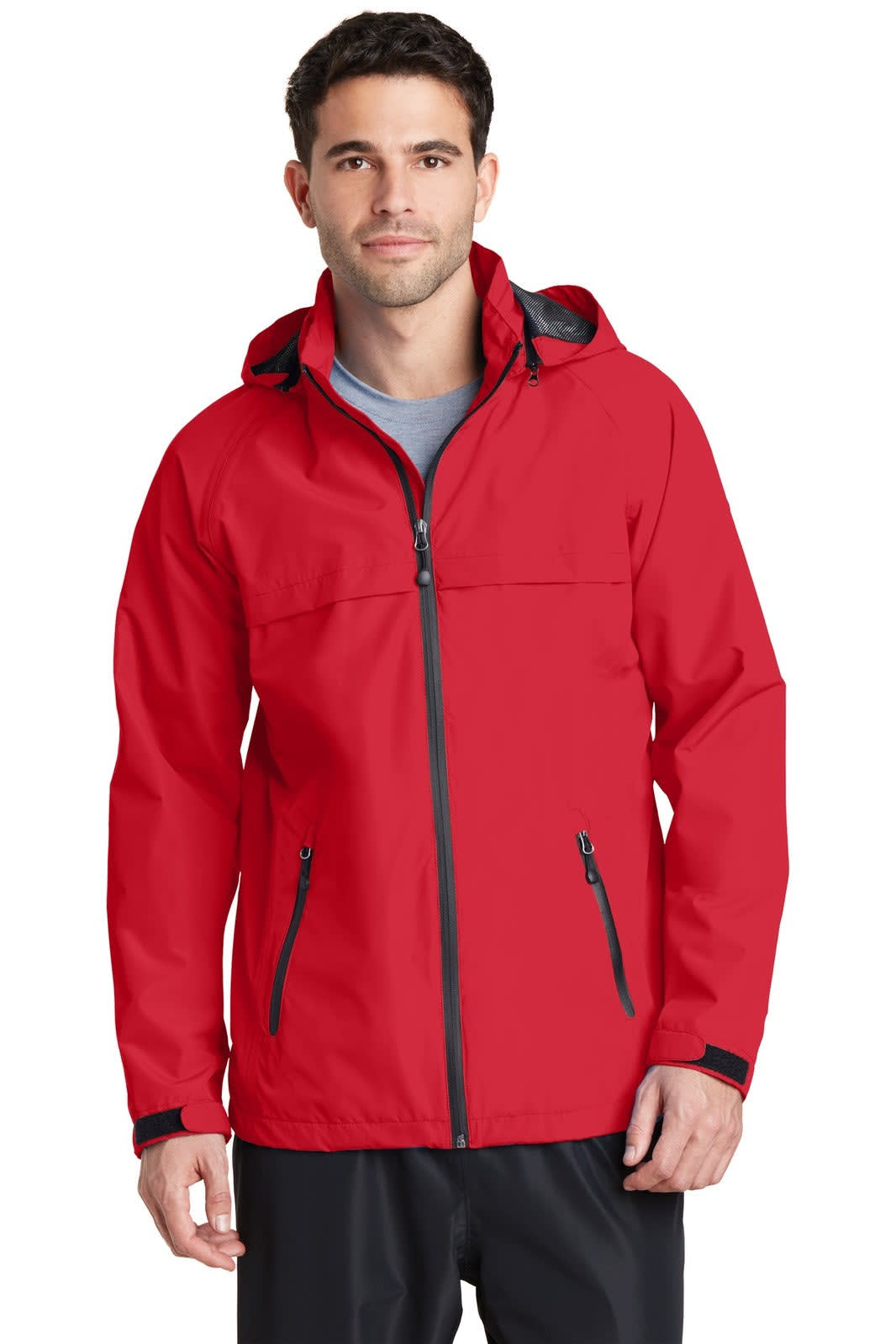 A man is wearing a bright red waterproof jacket with a hood, featuring zippered pockets and a branding logo.