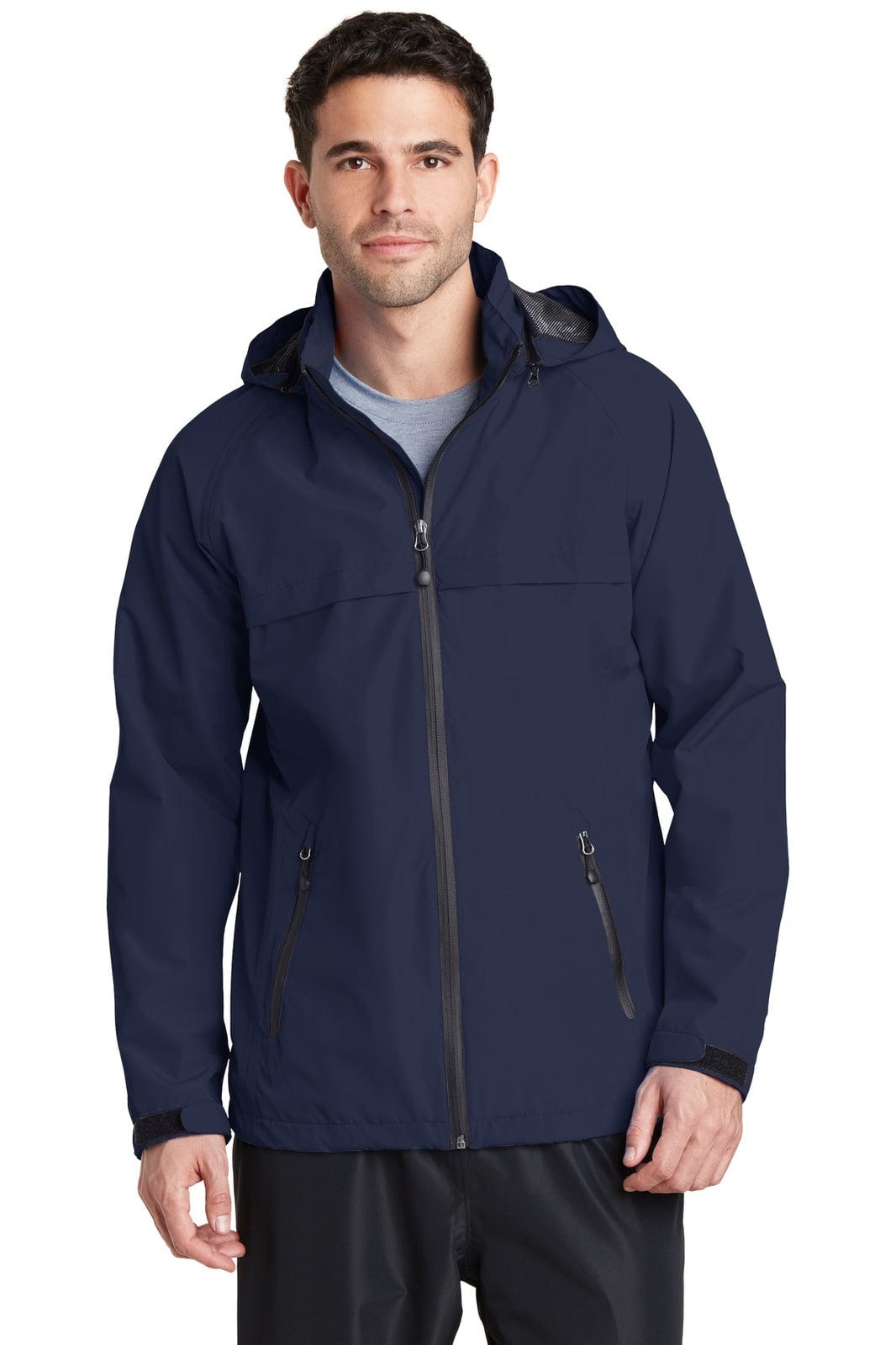 A man wearing a navy blue Port Authority Torrent Waterproof Jacket with a hood and zippered pockets. It has a logo.