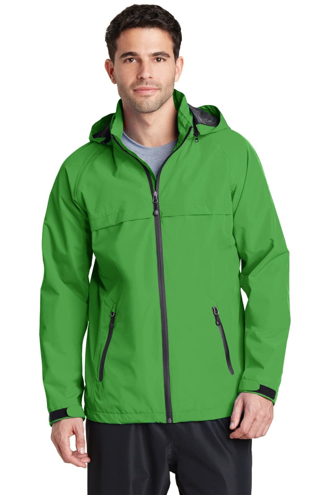 A man wearing a bright green waterproof jacket with a hood and zippered pockets, featuring a logo.