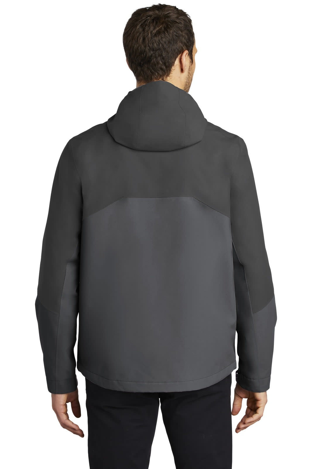 A man wearing a black and grey Port Authority Tech Rain Jacket, viewed from the back, with a hood.