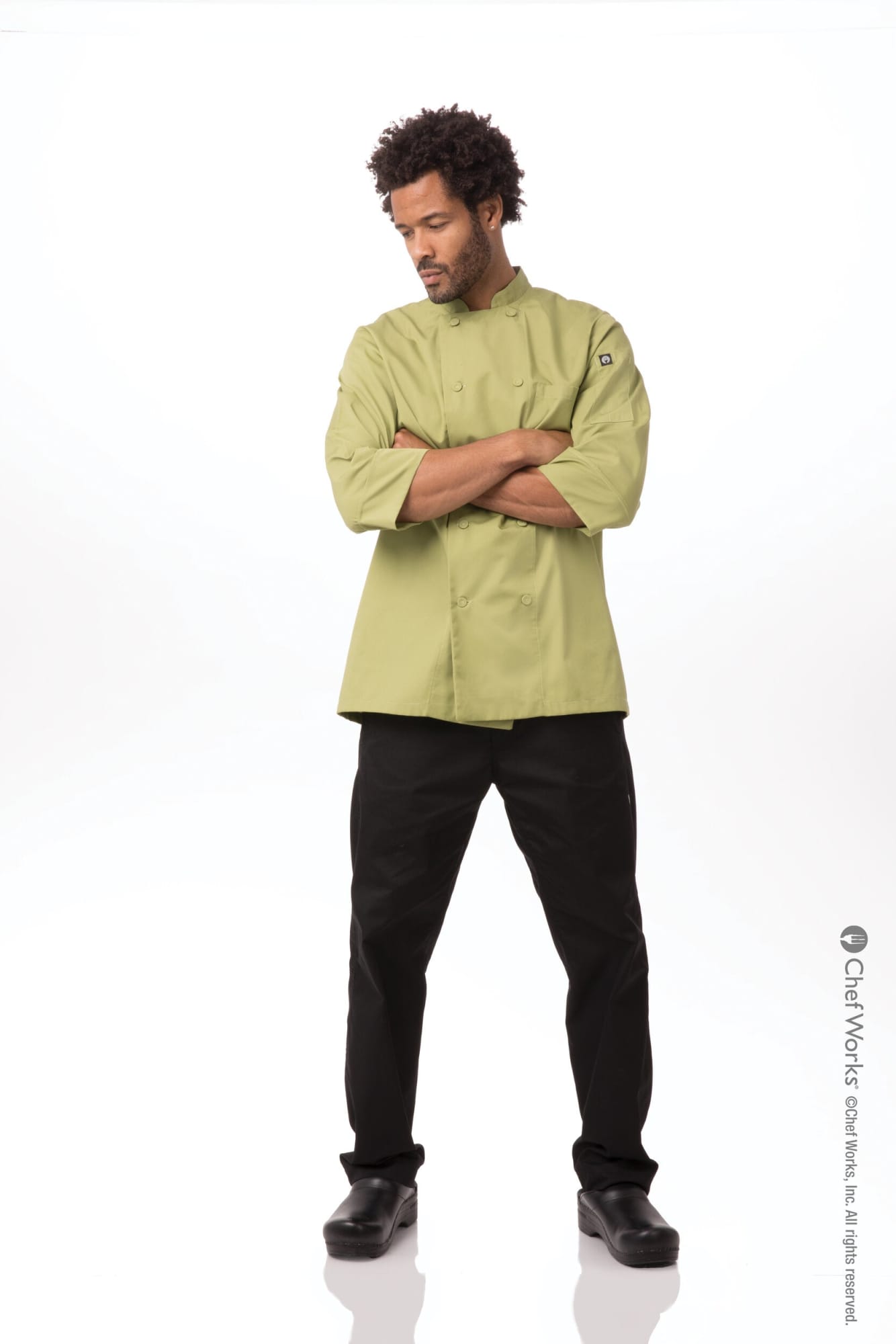 A men's chef jacket in olive green, paired with black pants, featuring a logo on the sleeve.