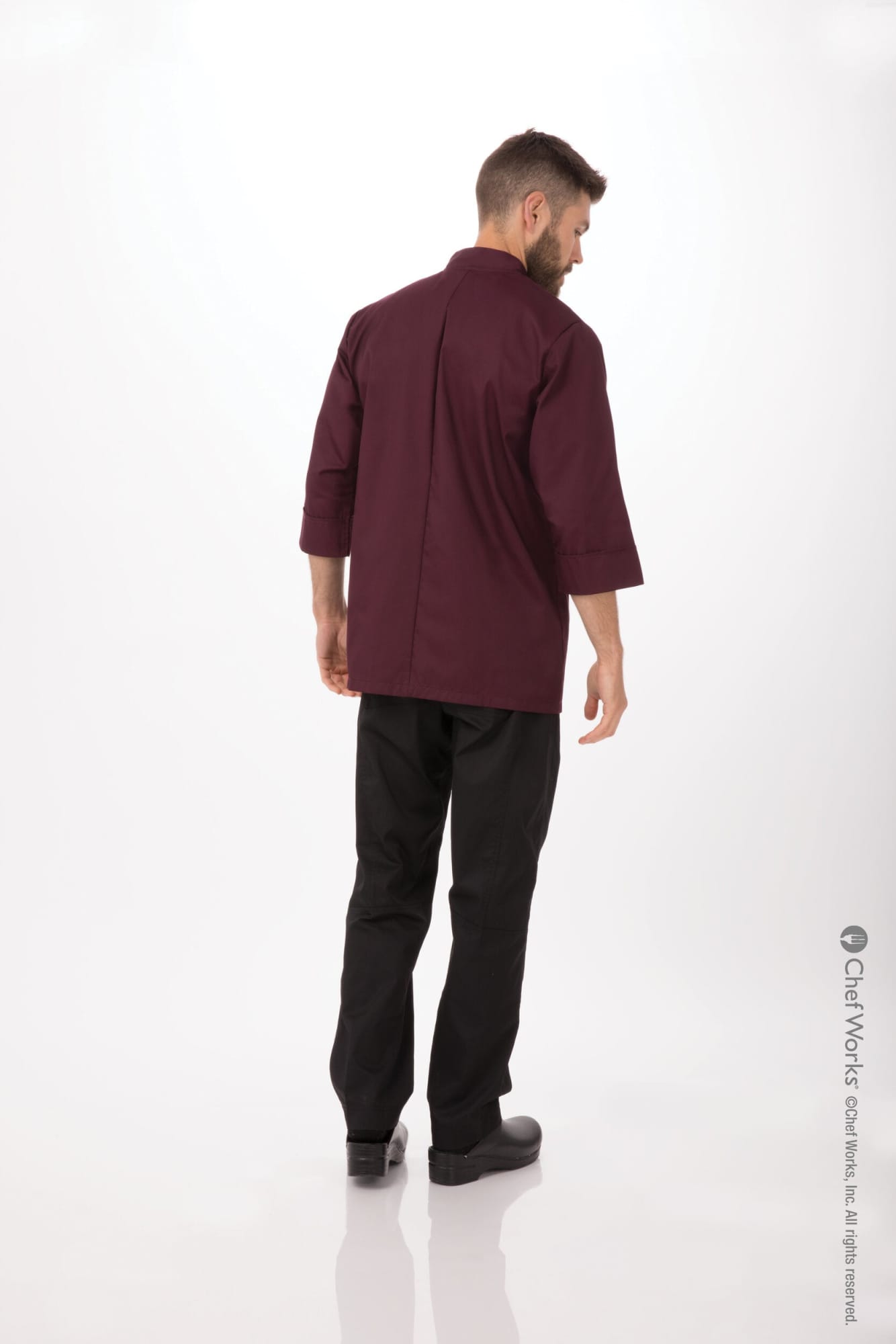 A maroon men's chef jacket with a back view, complemented by black trousers and shoes. It has a logo on the jacket.