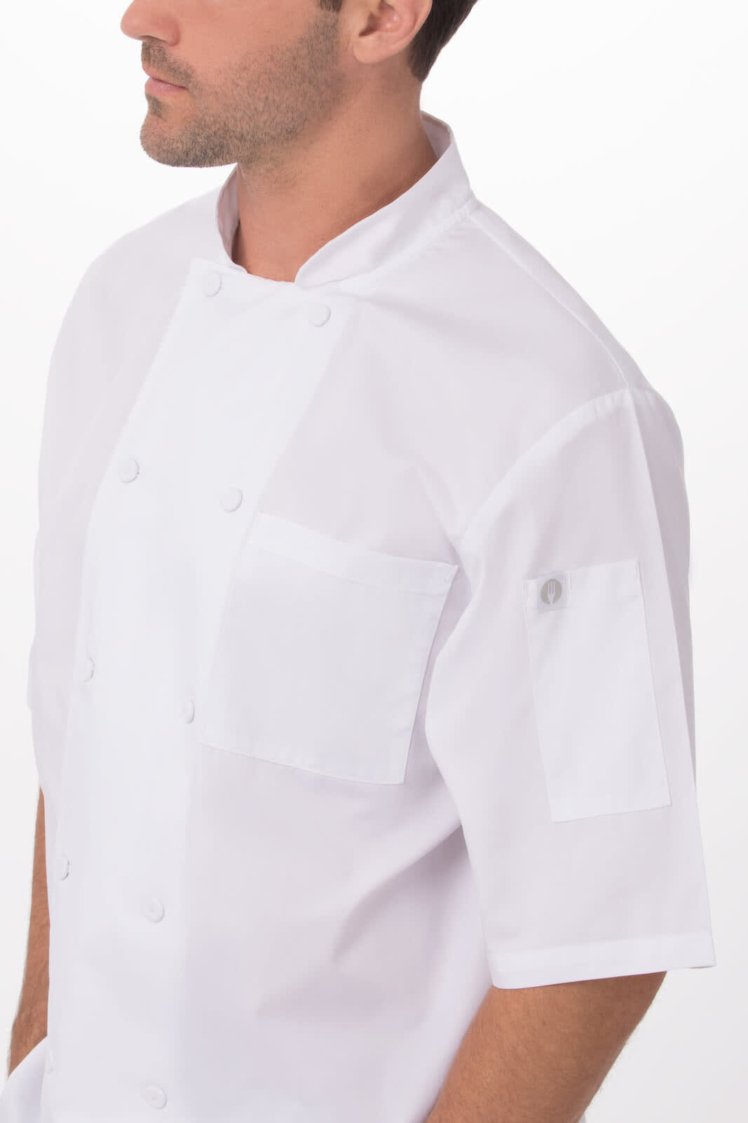 A white men's chef jacket featuring short sleeves and two pockets, complete with a logo on the sleeve.
