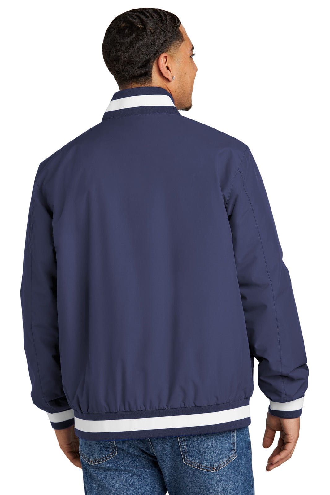 A man wearing a navy blue insulated varsity jacket with white striped detailing on the collar and cuffs.