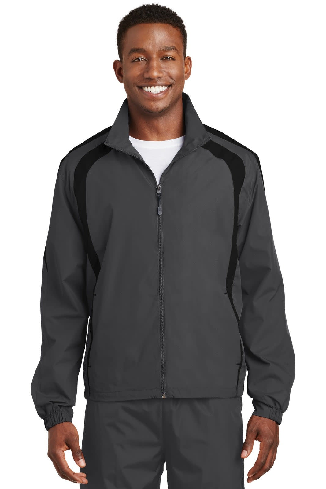 A man wearing a grey Sport-Tek Colorblock Raglan Jacket with black accents. The jacket includes a logo.