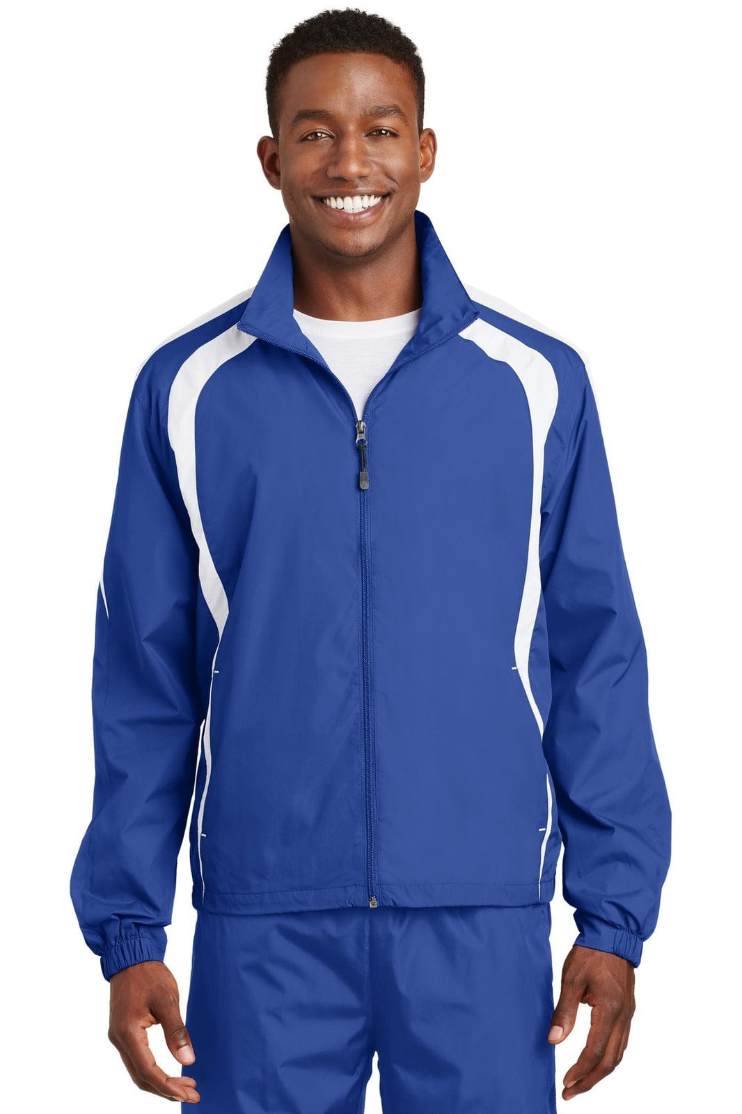 A blue Sport-Tek Colorblock Raglan Jacket featuring white accents and a zip front, worn by a smiling model.