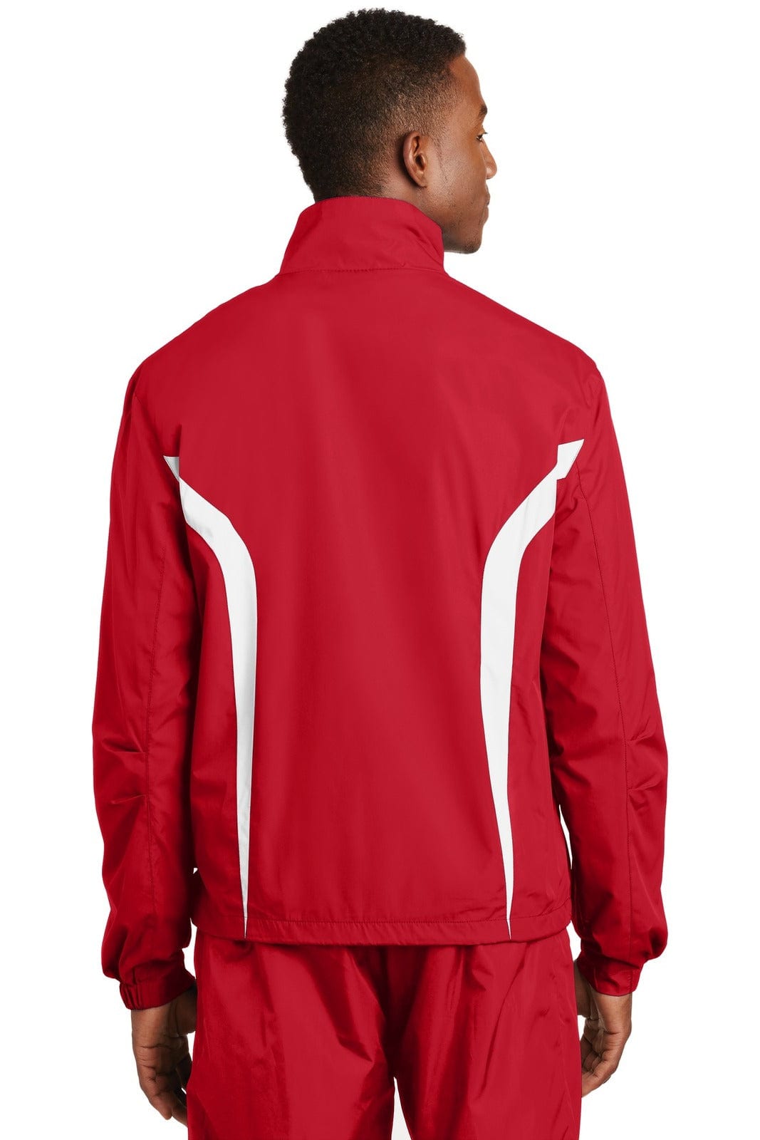 A red Sport-Tek Colorblock Raglan Jacket featuring white accents, viewed from the back with a person wearing it.