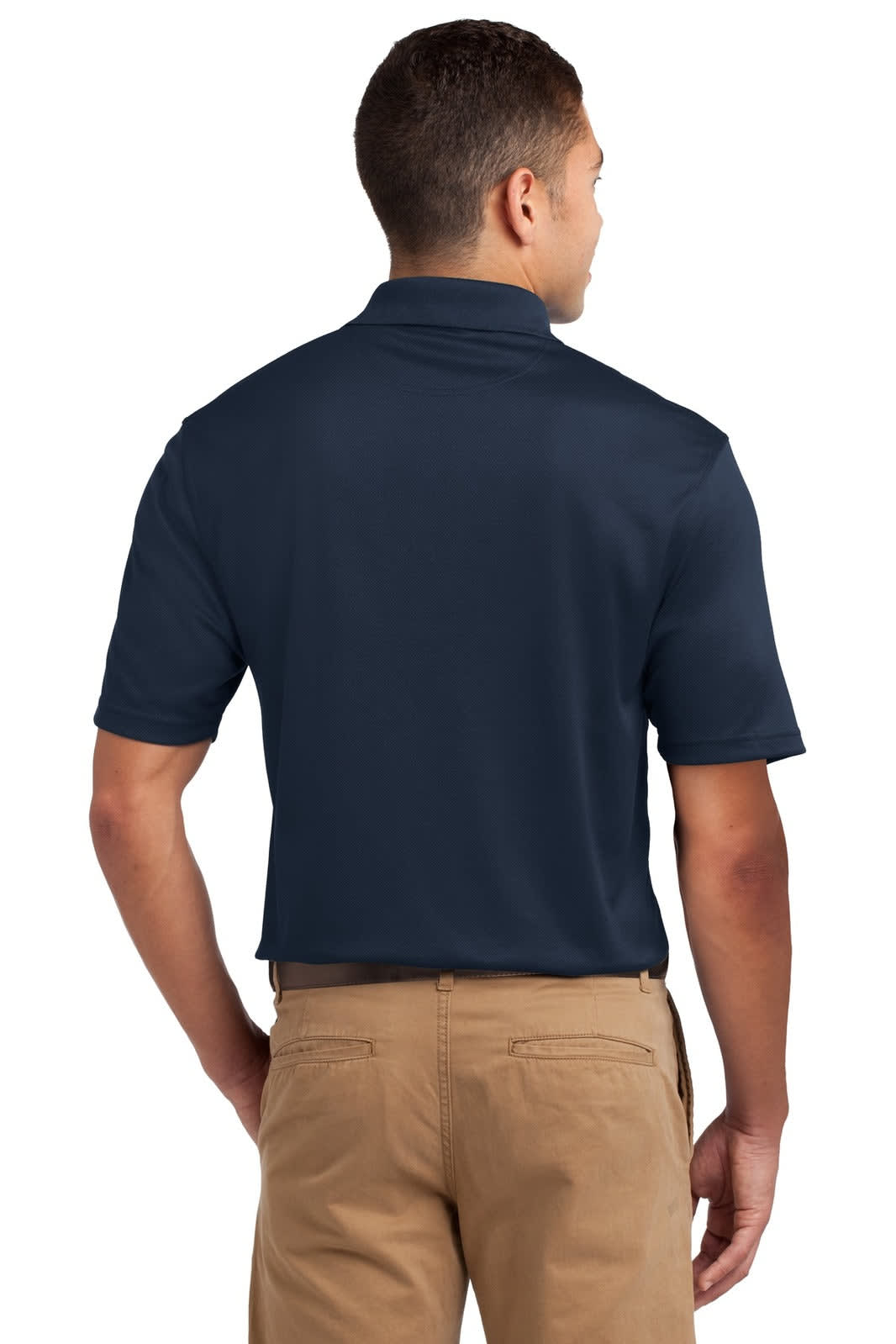 A navy Sport-Tek Dri-Mesh polo shirt, featuring a branded logo, displayed from the back on a model wearing khaki pants.