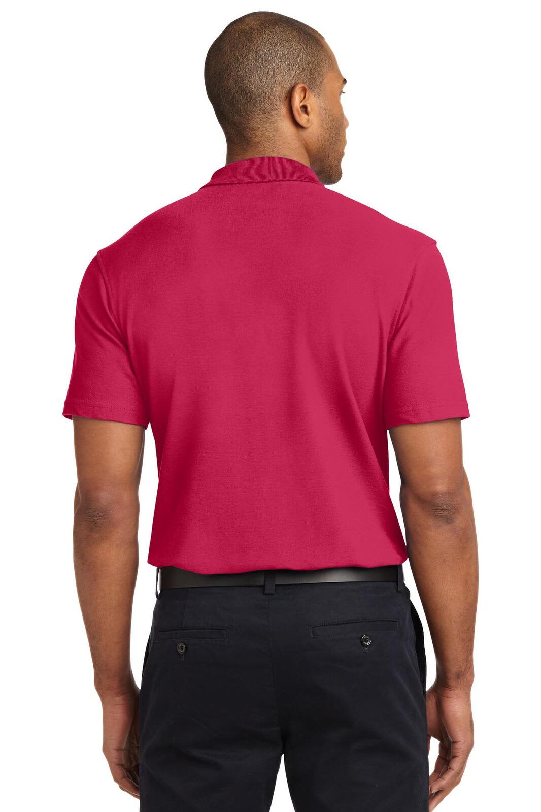 A man wearing a short-sleeved, stain-resistant polo shirt in bright pink, viewed from the back. The shirt features a logo.