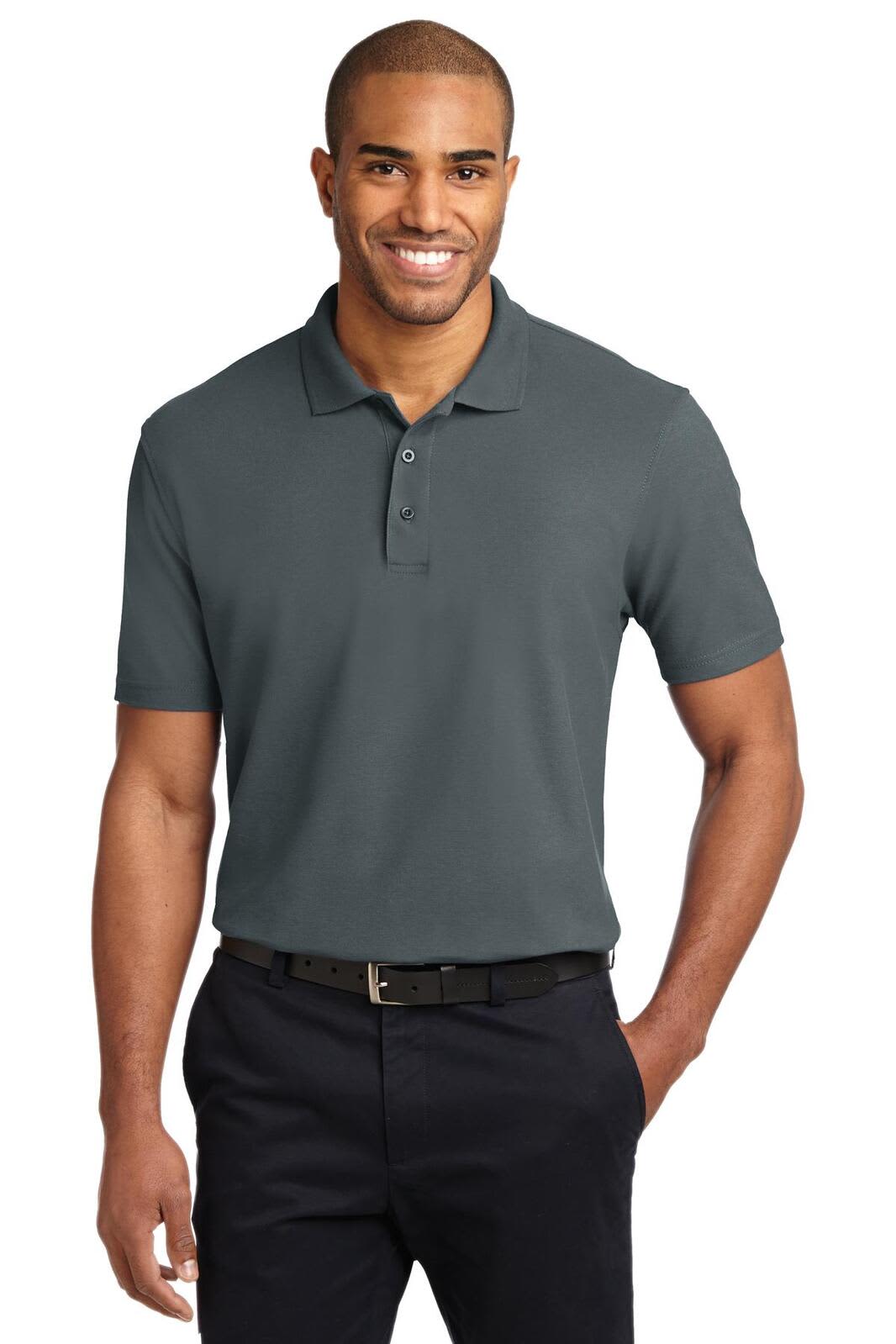 A man is wearing a grey stain-resistant polo shirt, paired with dark trousers, and smiling at the camera.