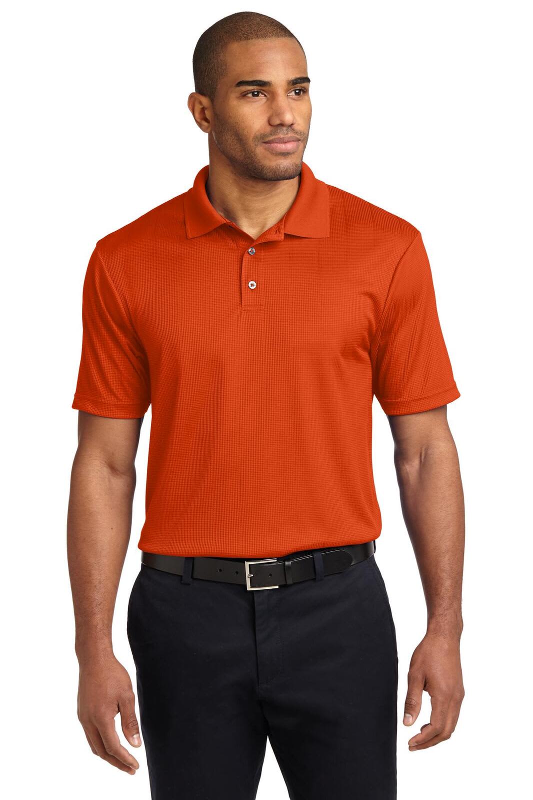 A model wearing an orange polo shirt, featuring a collar and short sleeves, paired with black trousers.