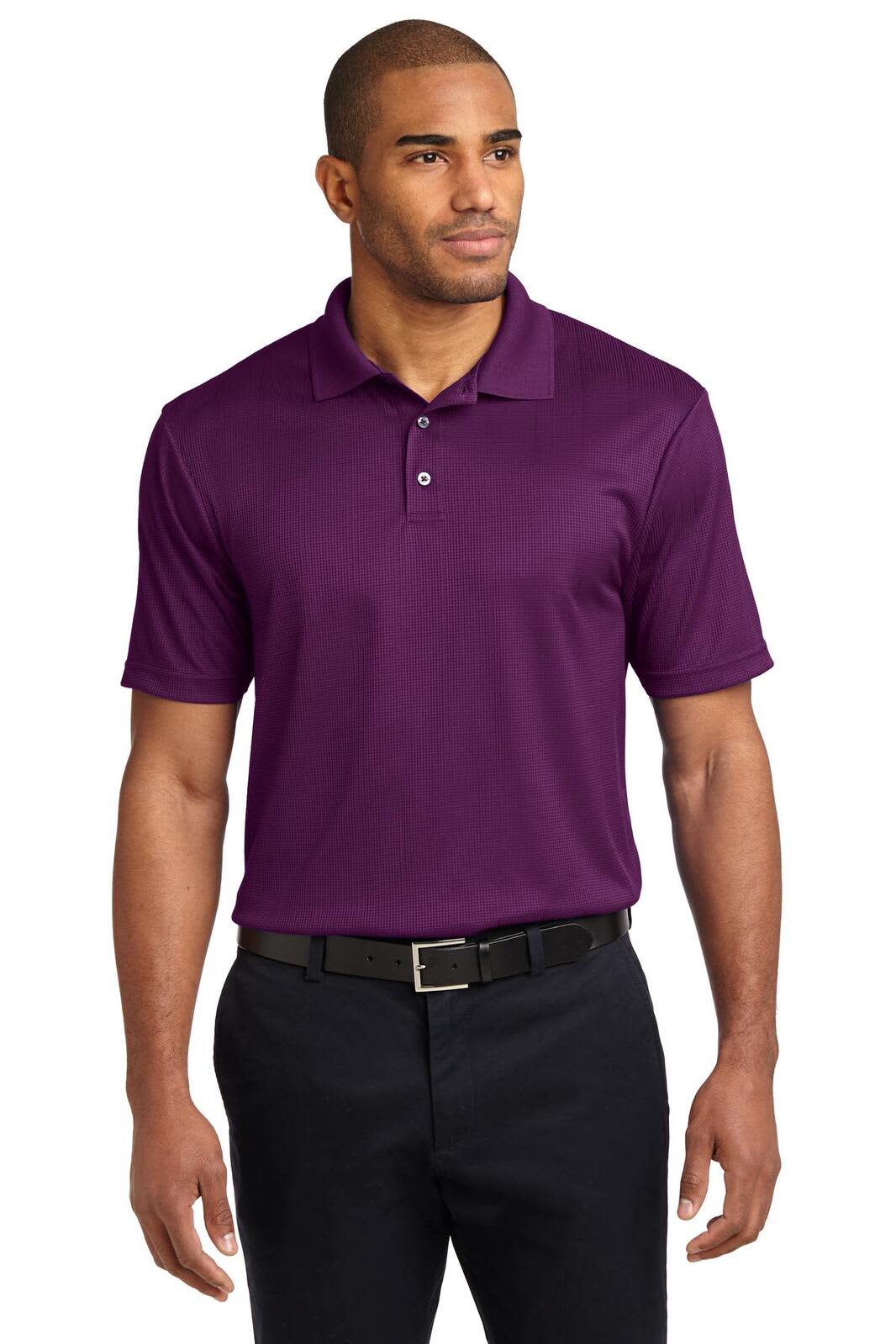 A man wearing a short-sleeved, purple polo shirt with a collar, paired with black trousers. The shirt has a logo.