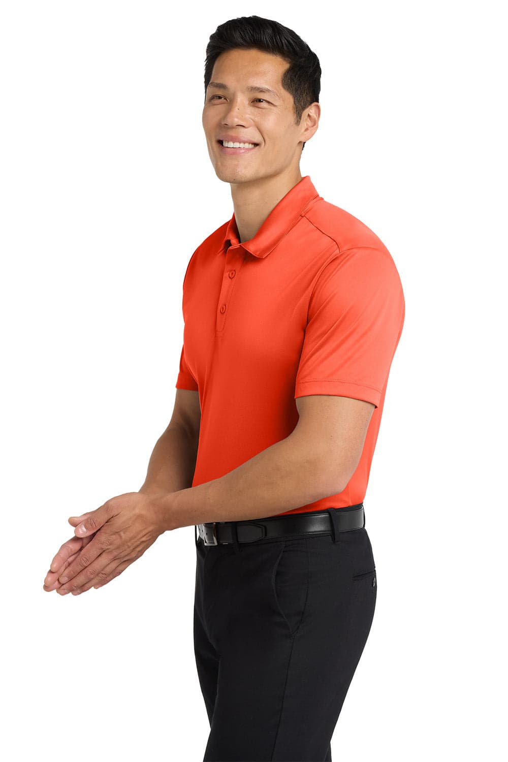 An orange Port Authority Silk Touch Performance Polo shirt displayed on a model wearing black trousers, with a logo present.