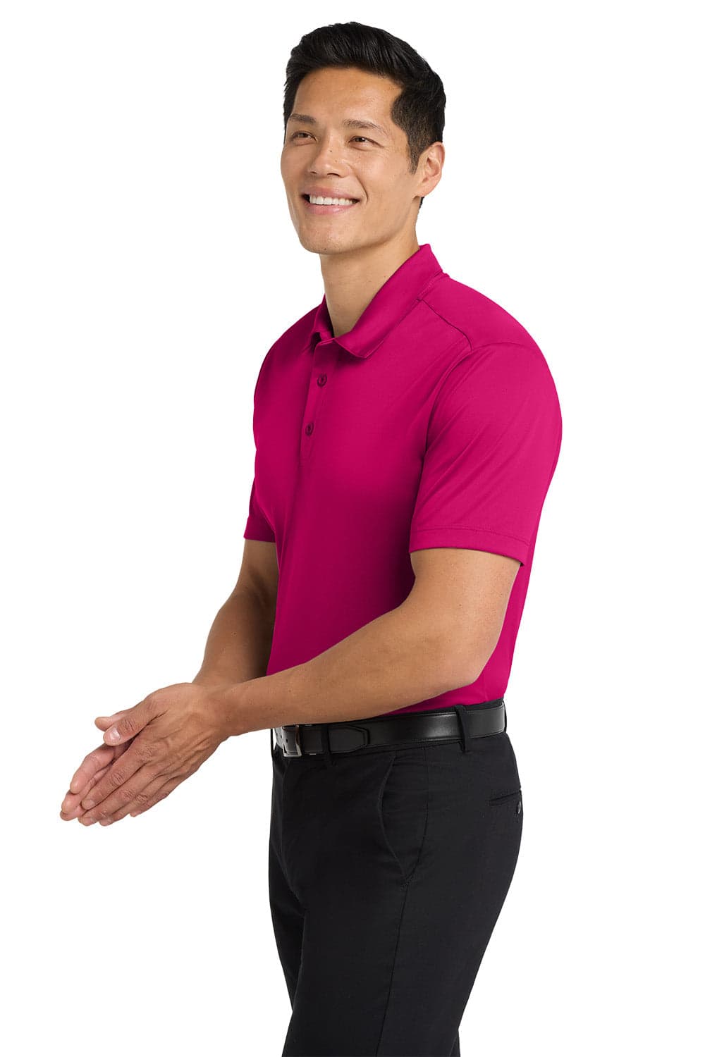 A man wearing a bright pink polo shirt stands with his hands clasped, accompanied by black trousers. The shirt has a logo.