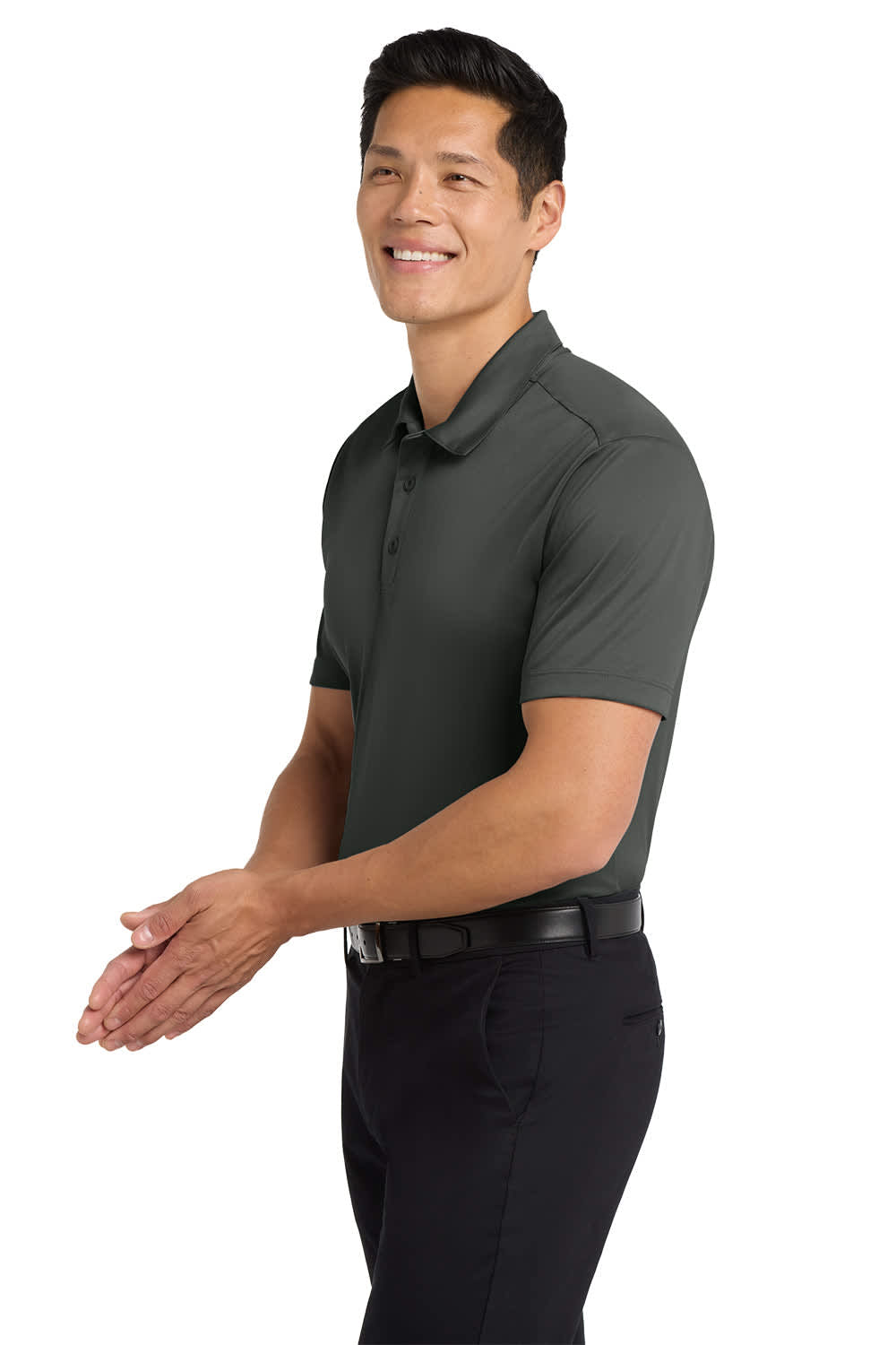 A man wearing a dark green Port Authority Silk Touch Performance Polo paired with black trousers, smiling while clapping.