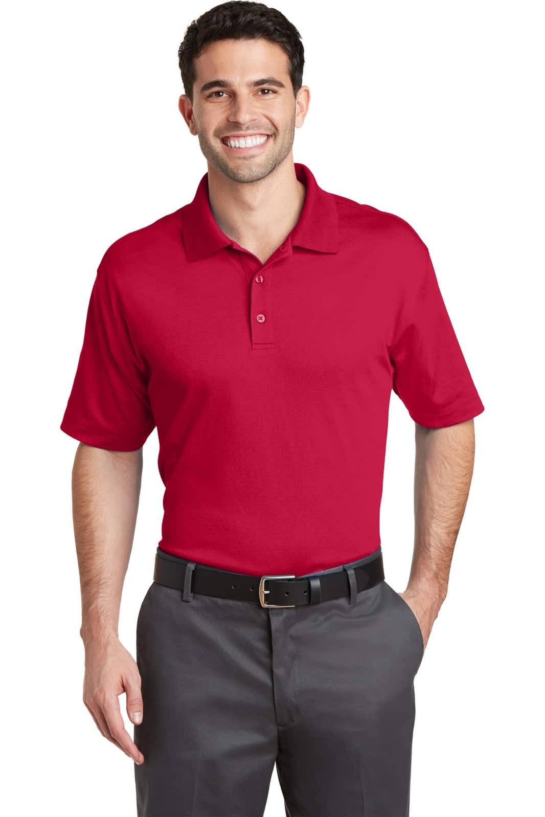 A red polo shirt features a collar and two buttons, worn by a smiling man with dark hair and grey pants.