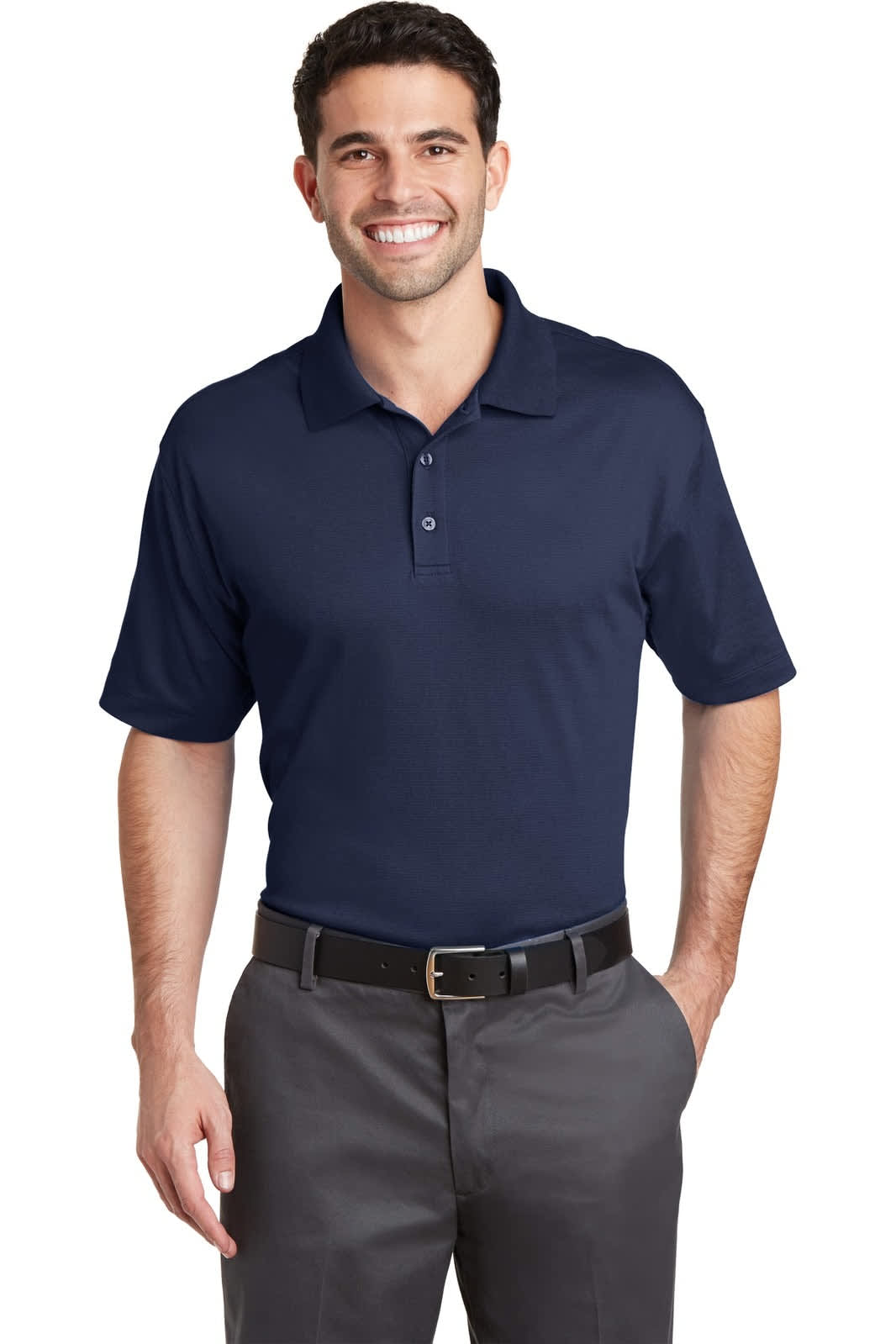 A man wearing a navy blue Port Authority Rapid Dry Mesh Polo shirt, paired with grey trousers, and smiling.