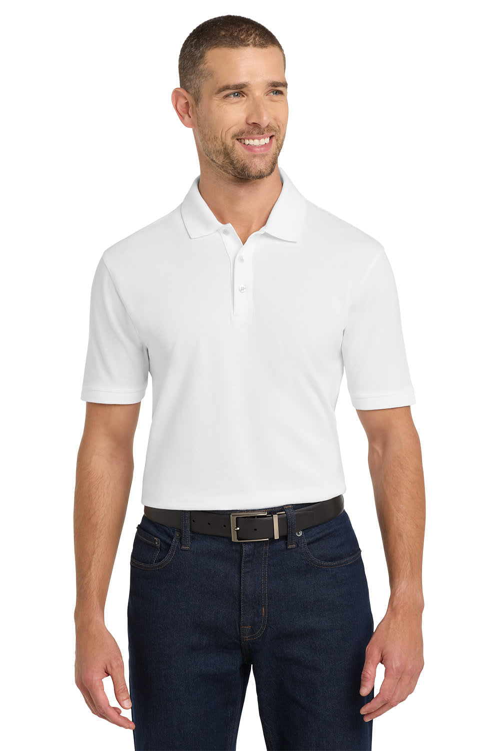 A man wearing a white Port Authority EZCotton polo shirt paired with dark jeans and a belt. The shirt features a logo.