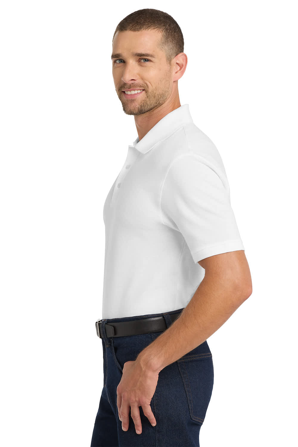 A man wearing a white Port Authority EZCotton polo shirt, standing sideways with a smile, showcasing a casual style.