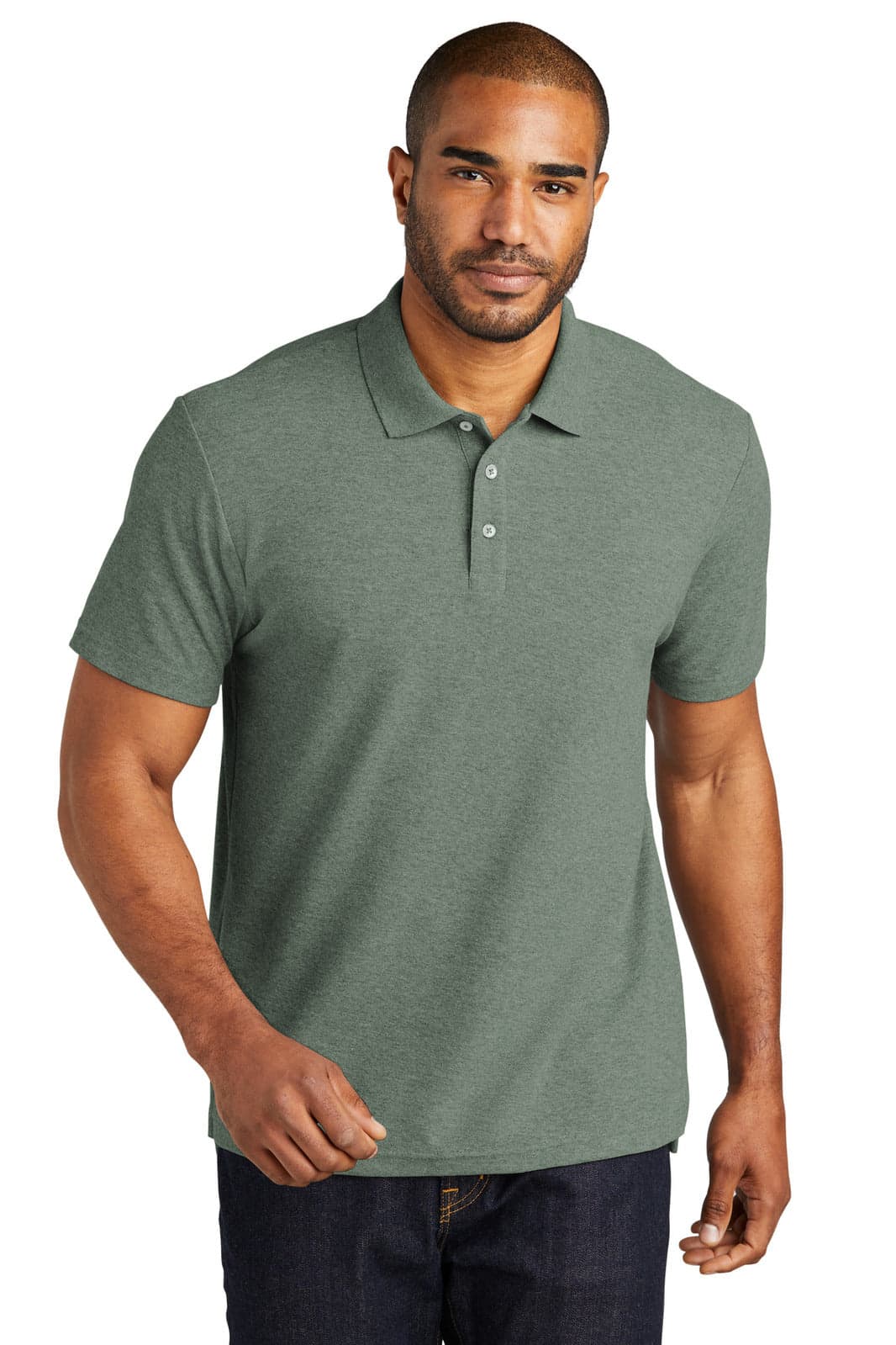 A man is wearing a green Port Authority C-FREE Cotton Blend Pique Polo, featuring a collar and buttons.