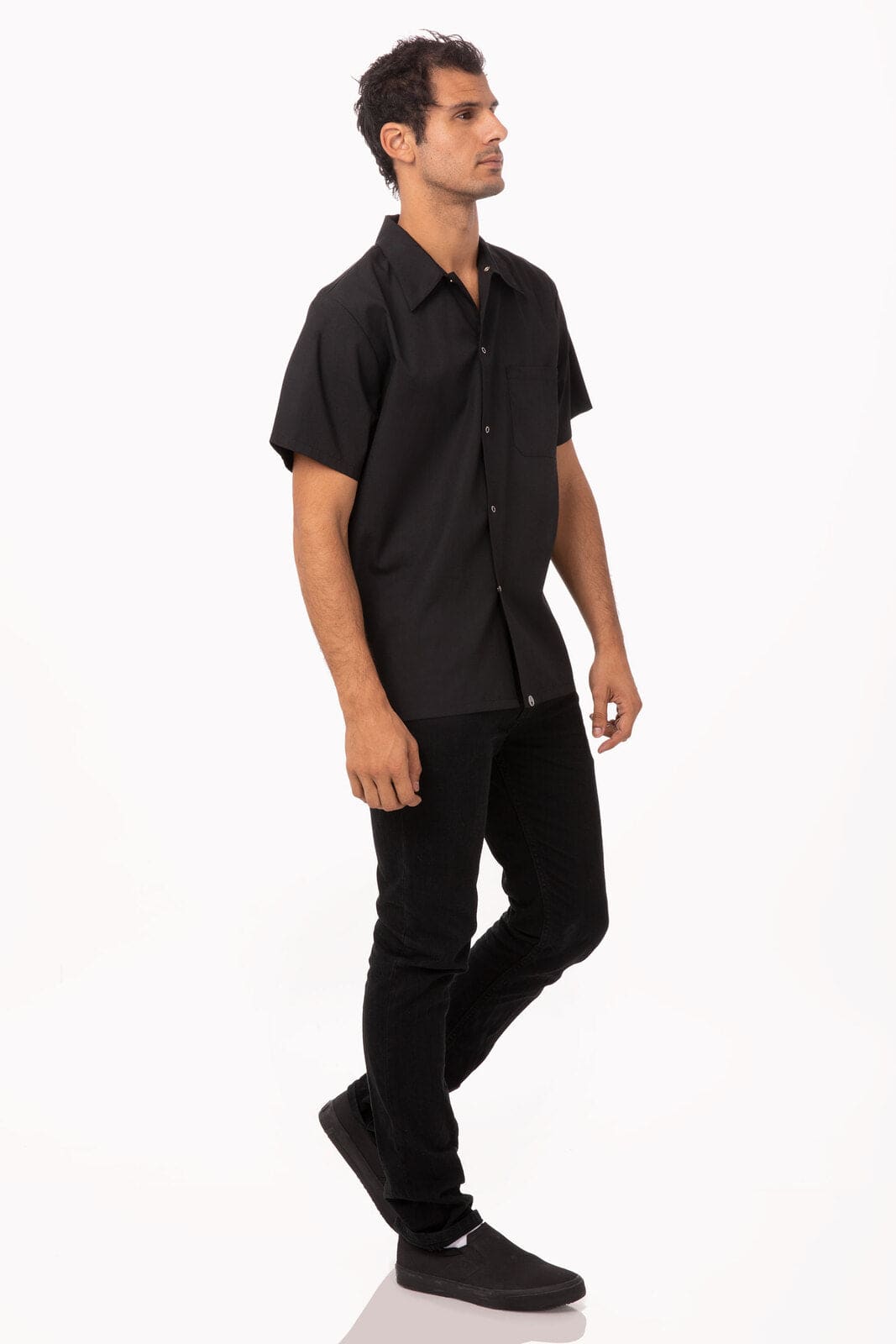 A black utility cook shirt with short sleeves, paired with black pants and shoes, worn by a standing male model.
