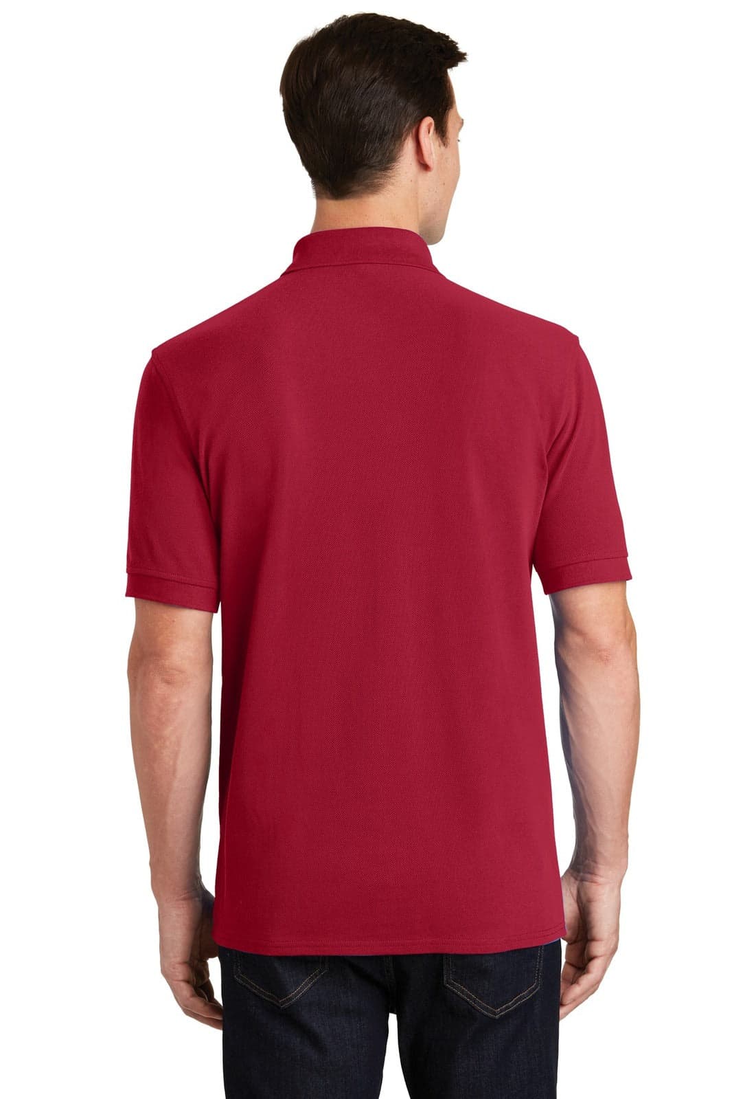 A man wearing a red Port & Company ring spun pique polo shirt, viewed from the back, with a logo present.