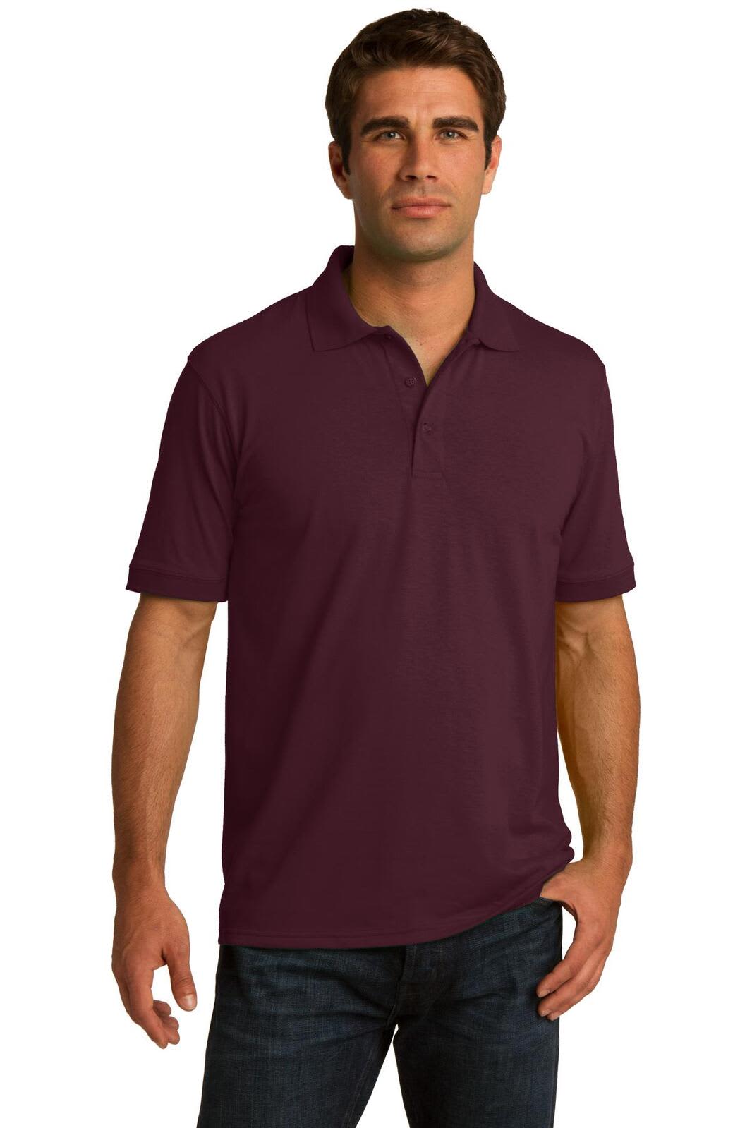 A man wearing a maroon polo shirt, featuring a collar and logo, paired with dark jeans.