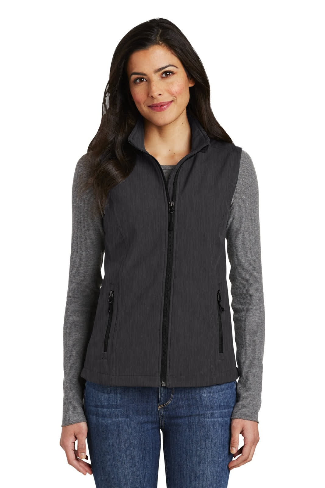 A grey soft shell vest with a zip front and two side pockets, worn over a long-sleeve shirt. Features a logo.