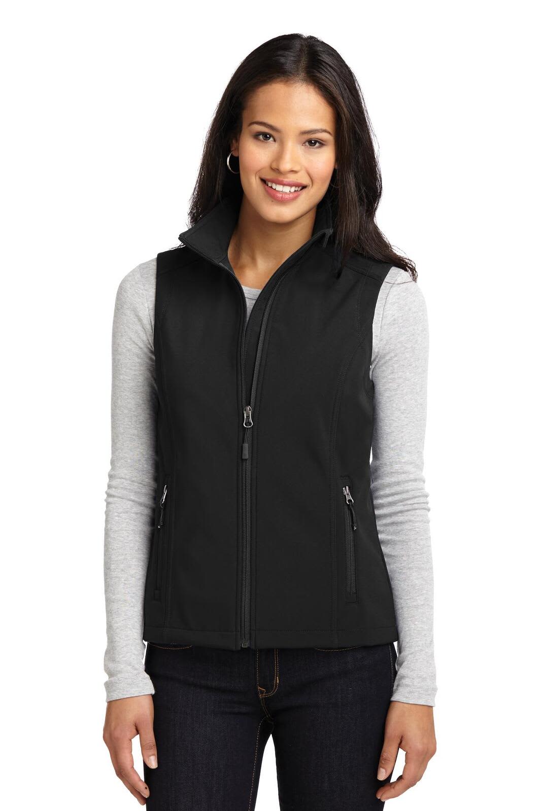 A woman wearing a black soft shell vest over a grey long-sleeve top, with a casual pose and a branding logo on the vest.
