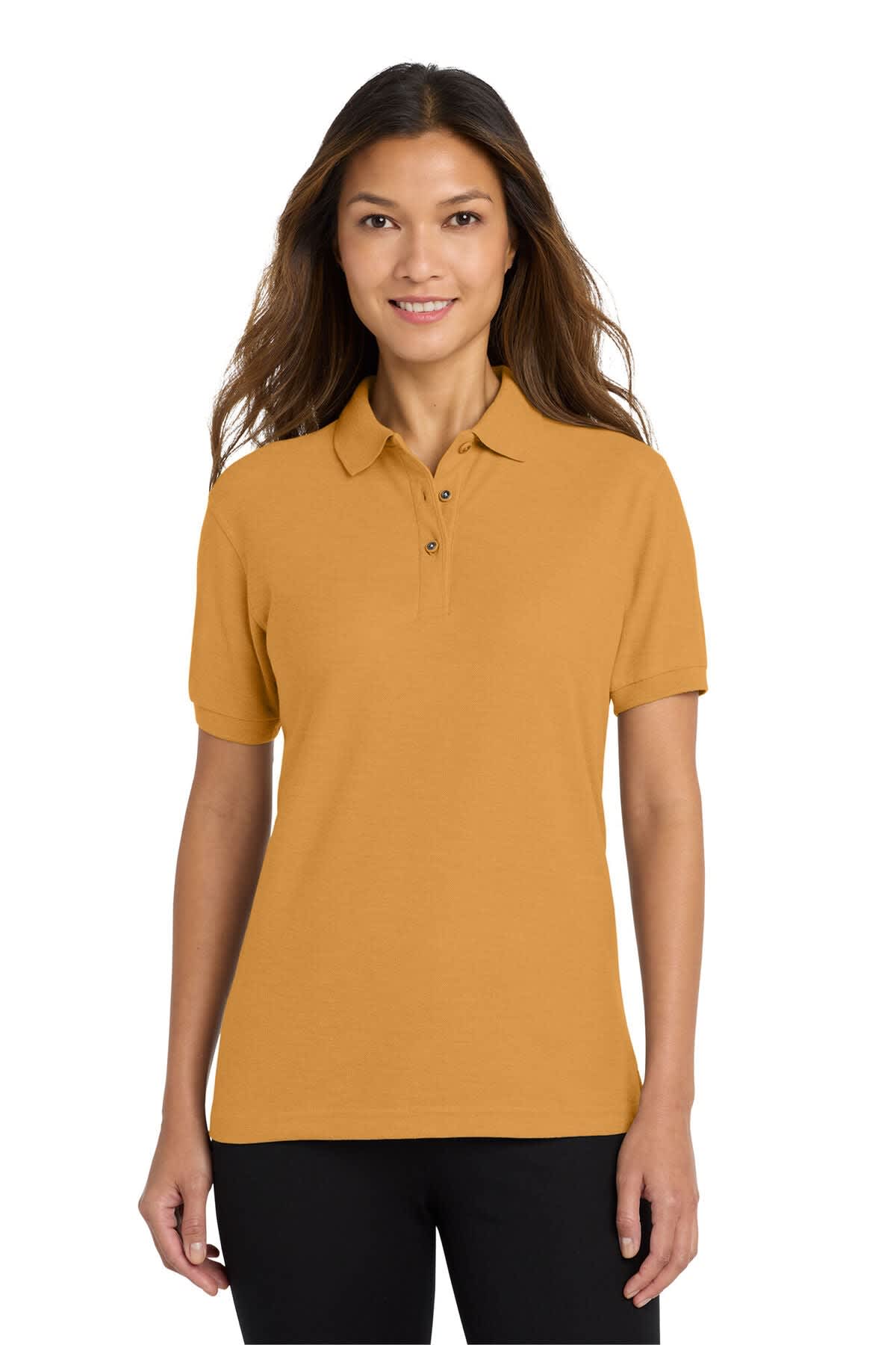 A woman models a ladies' polo shirt in a warm gold colour, featuring a logo on the chest and a classic collar.