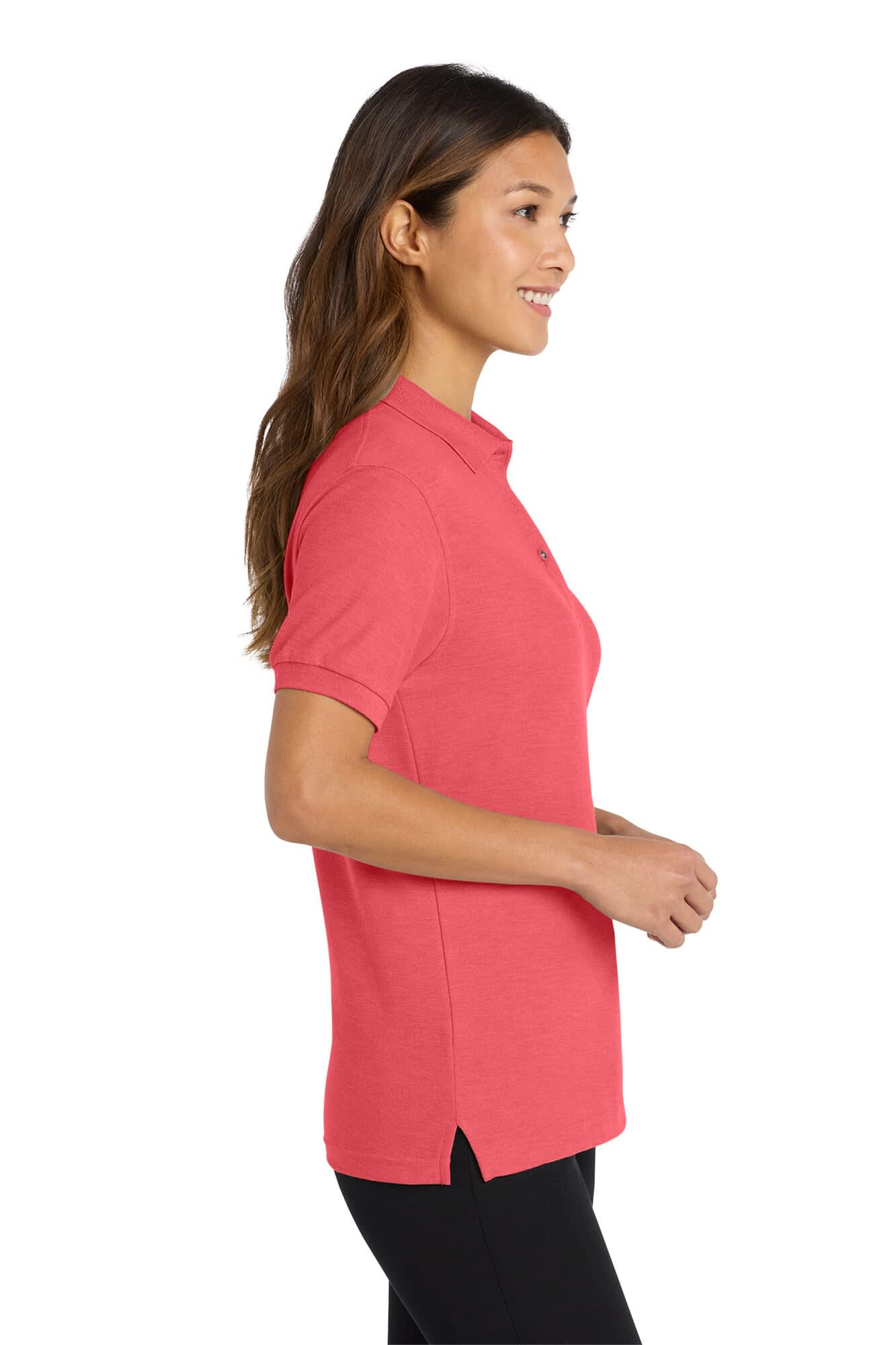 A pink ladies' polo shirt with a side split and a logo. Positioned on a woman facing to the right.
