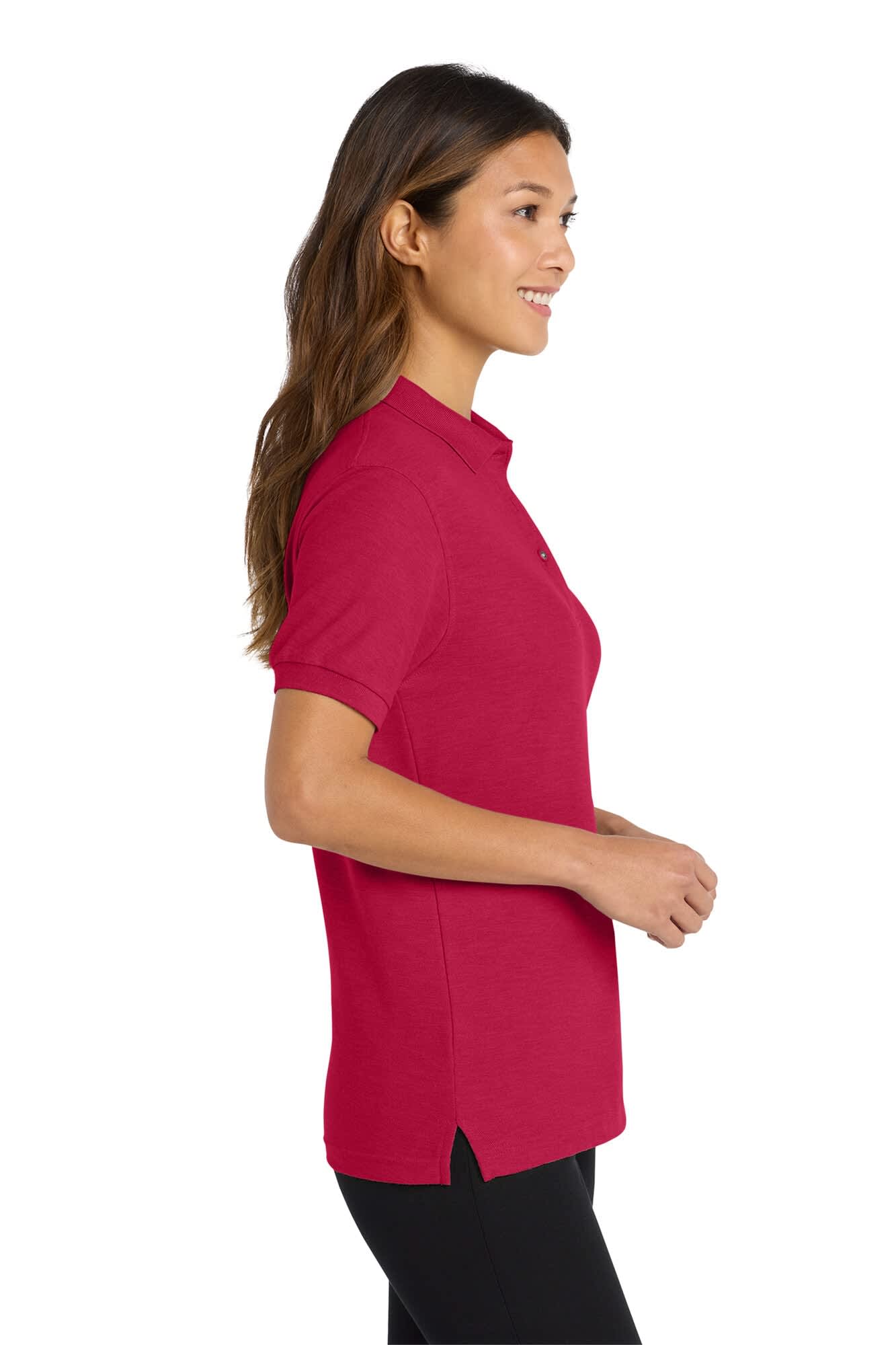 A side view of a woman wearing a pink Port Authority Ladies Silk Touch Polo shirt with a logo.