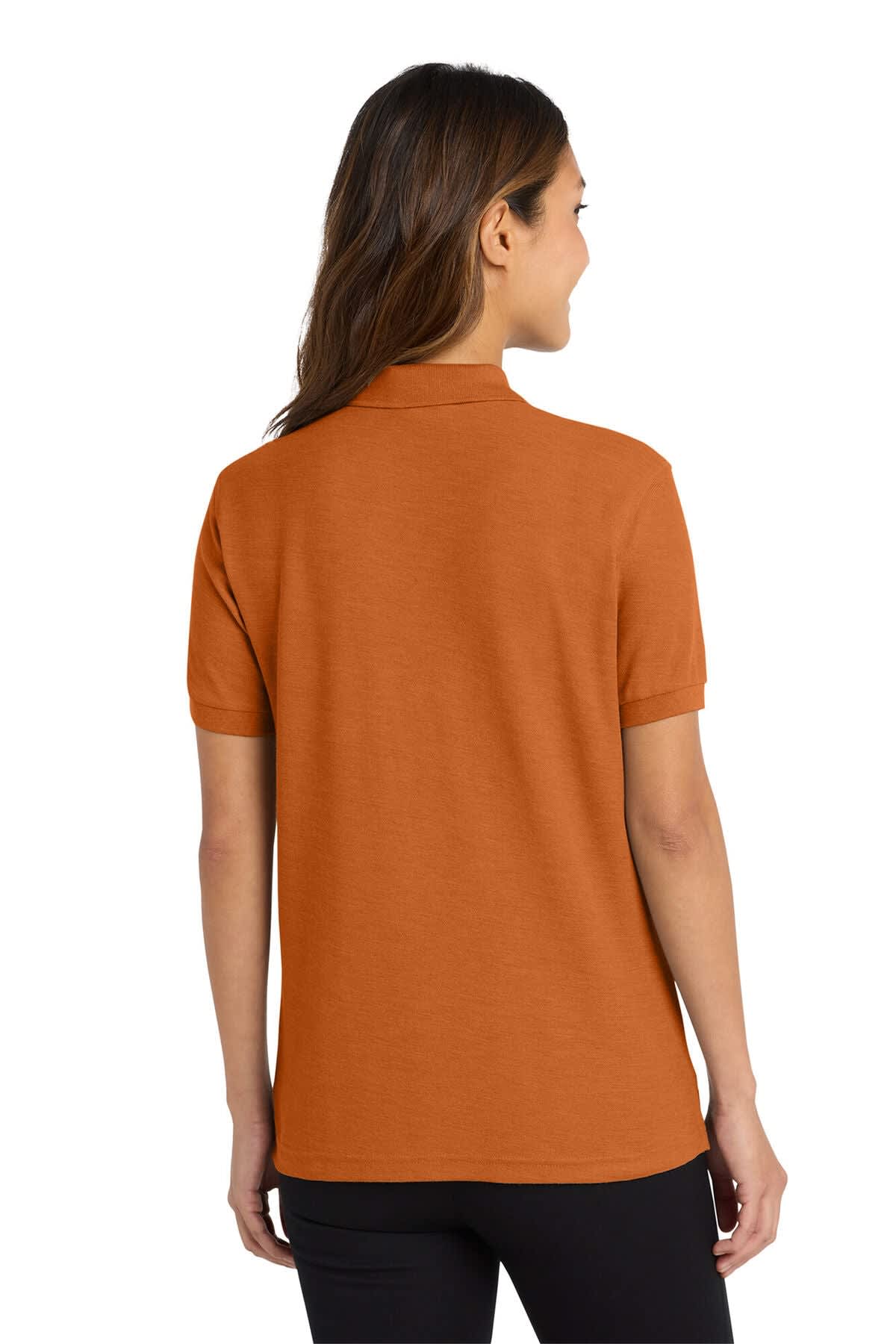 A ladies' polo shirt in burnt orange, featuring a classic collar and short sleeves, with a logo on the back.