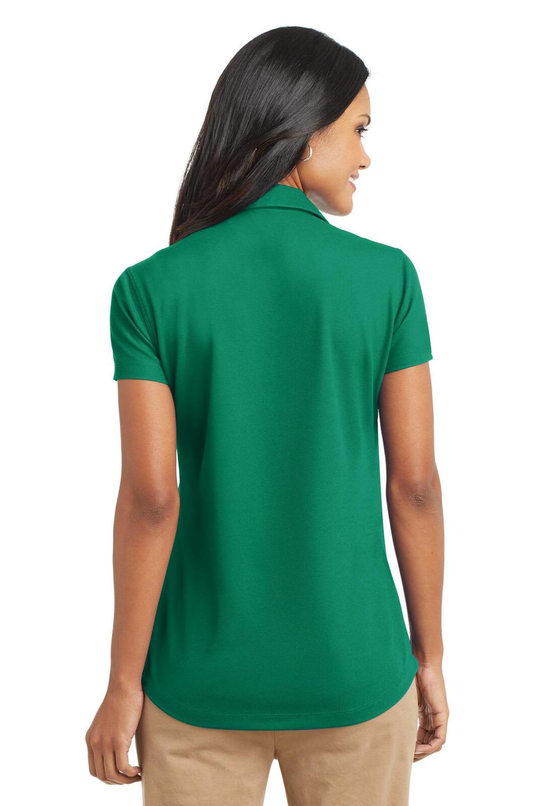 A women's green polo shirt with a short sleeve and a subtle collar, featuring a logo on the back.