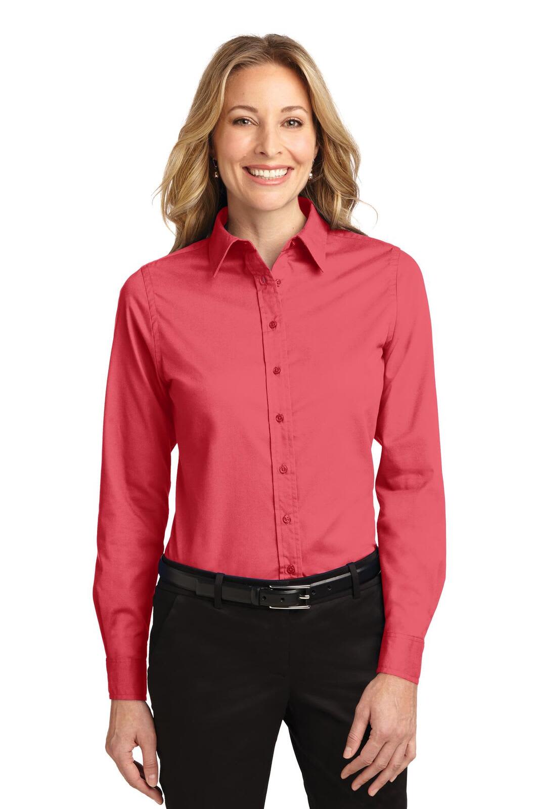 A woman wearing a red long sleeve button-up shirt, paired with black trousers and a black belt. The shirt has a logo.