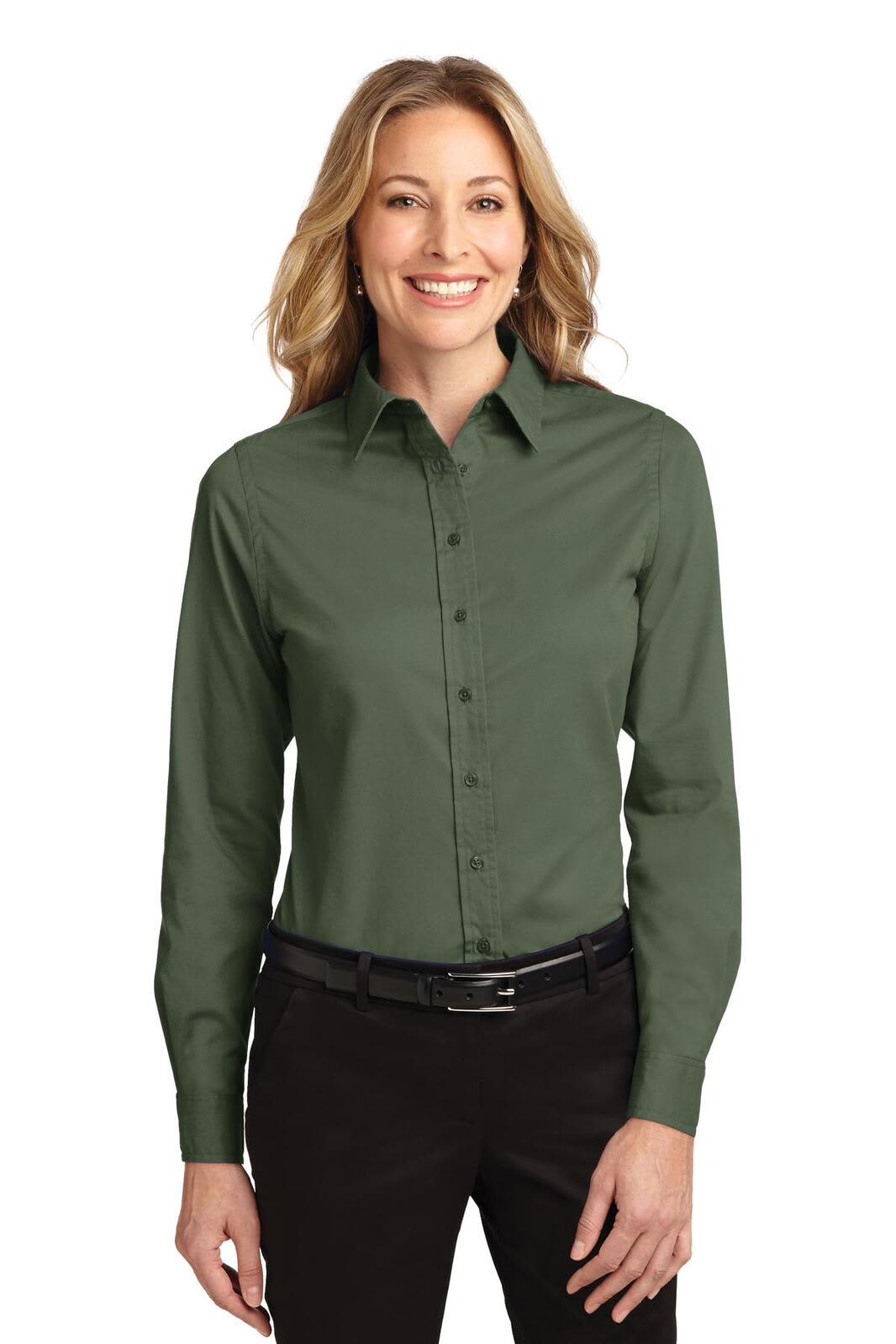 A long sleeve, button-up shirt in dark green, featuring a collar and a logo. Model is smiling while wearing it.