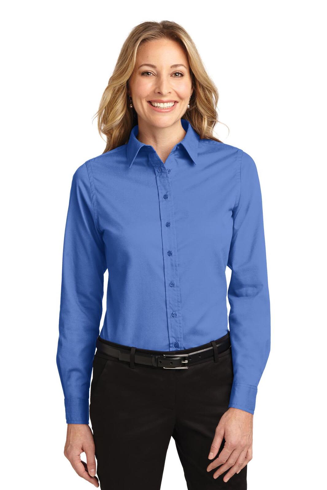A long-sleeve button-up shirt in blue, featuring a collar and a branding logo, worn by a smiling model.