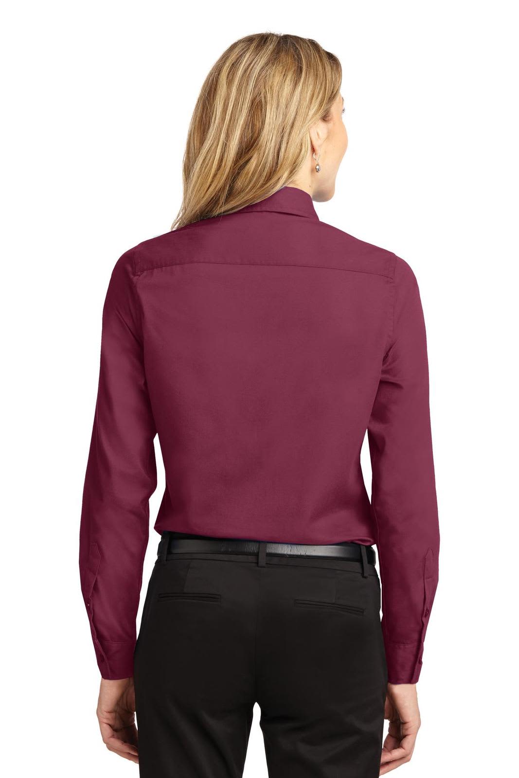 A women's long sleeve button-up shirt in burgundy, featuring a collar and a subtle logo.