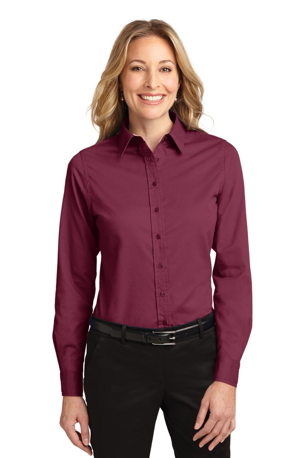 A long sleeve button-up shirt in burgundy, featuring a collar and a logo, worn by a woman.