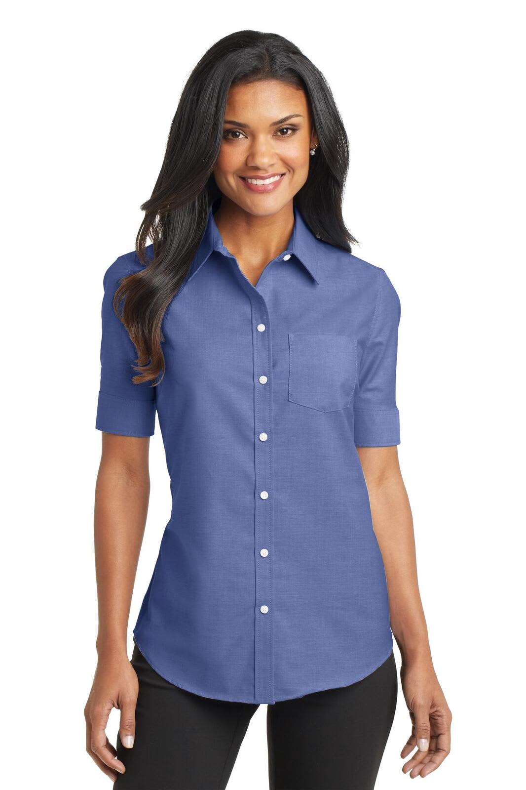 A woman in a blue, short-sleeve button-up shirt with a chest pocket and a logo.
