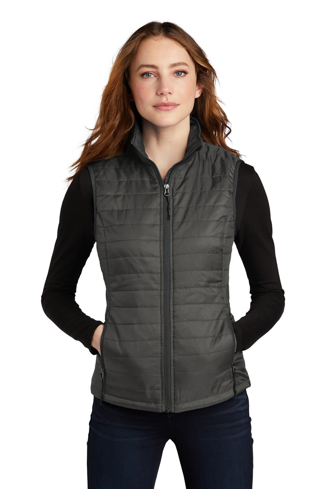 A grey packable puffy vest featuring a zip front and two side pockets, worn over a long-sleeve top.