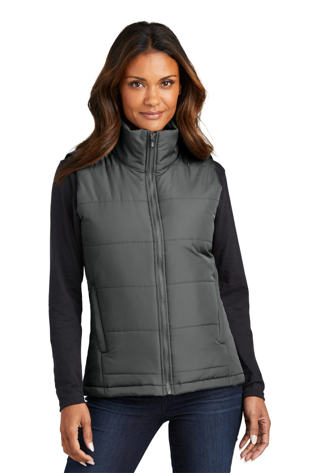 A woman models a grey puffer vest with a high collar, paired with a black long-sleeve top. The vest includes a logo.