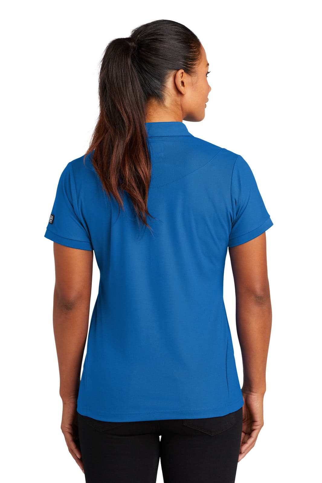 A blue OGIO Jewel Polo shirt is shown from the back, featuring a fitted design and short sleeves.